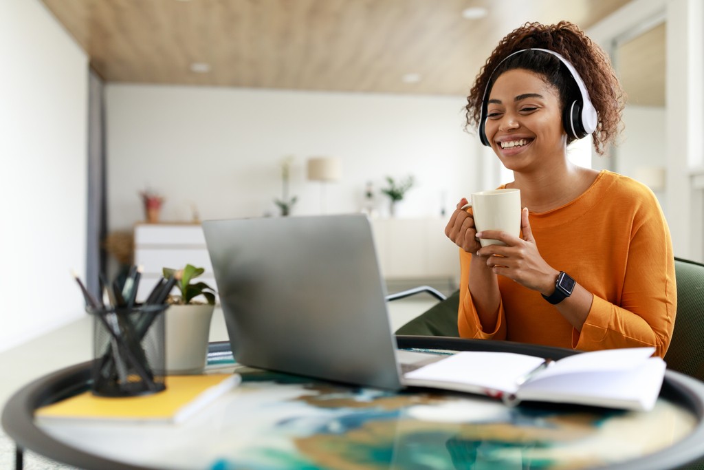 a woman wearing headphones and holding a cup of coffee