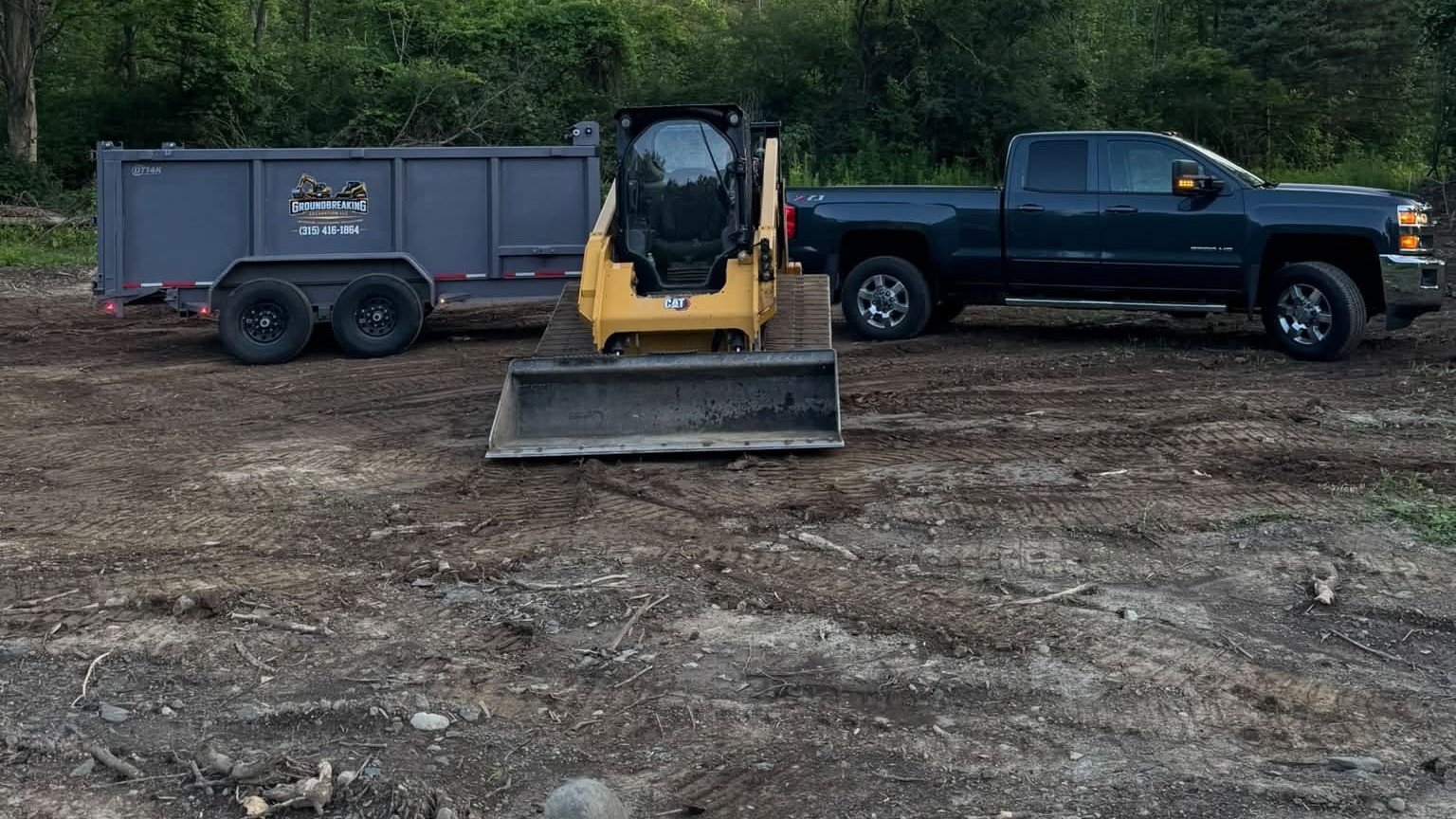 GroundBreaking Excavation dump trailer, skid steer, and truck on a graded job site in Onondaga County, NY