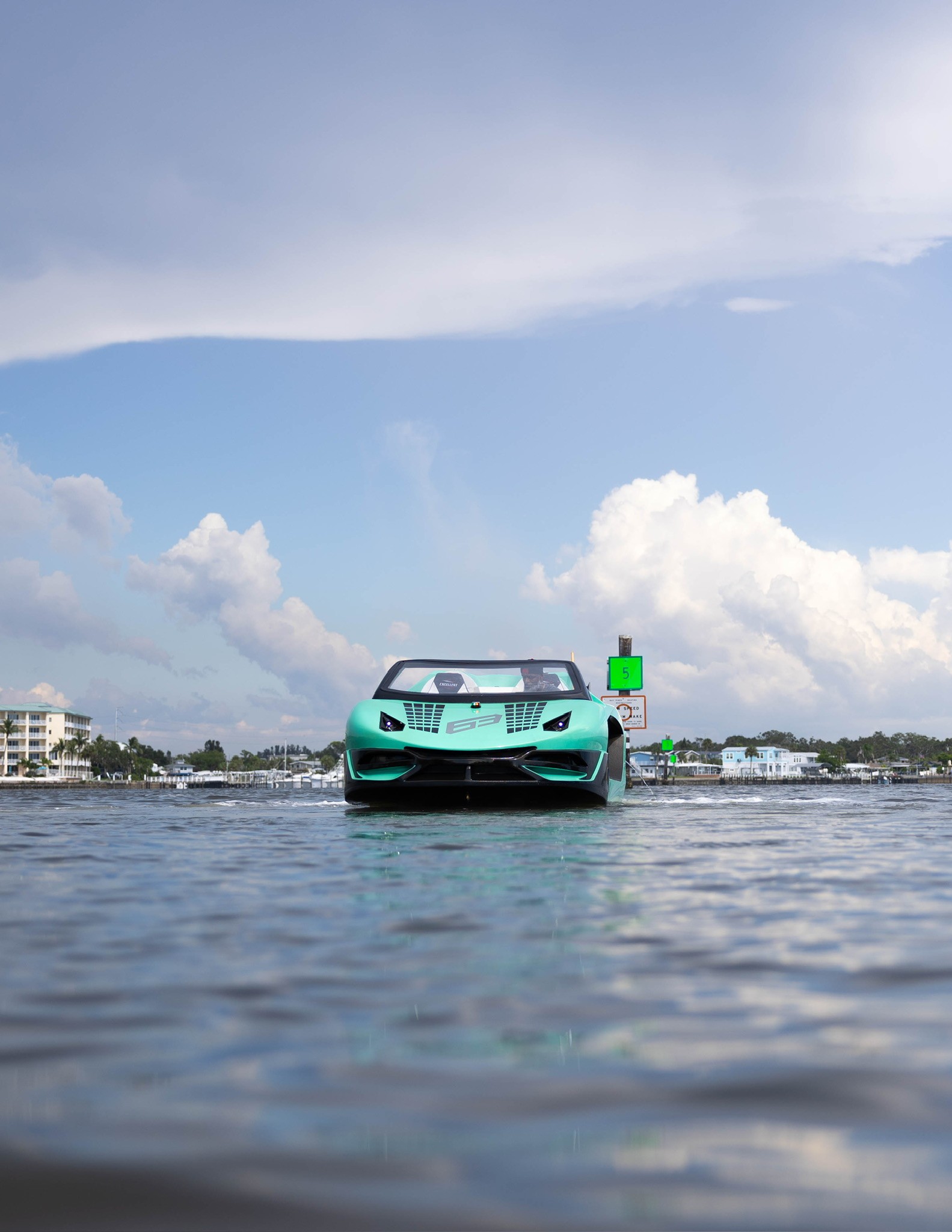 A group of six people gather around a wooden table where an older man in an apron kneads dough