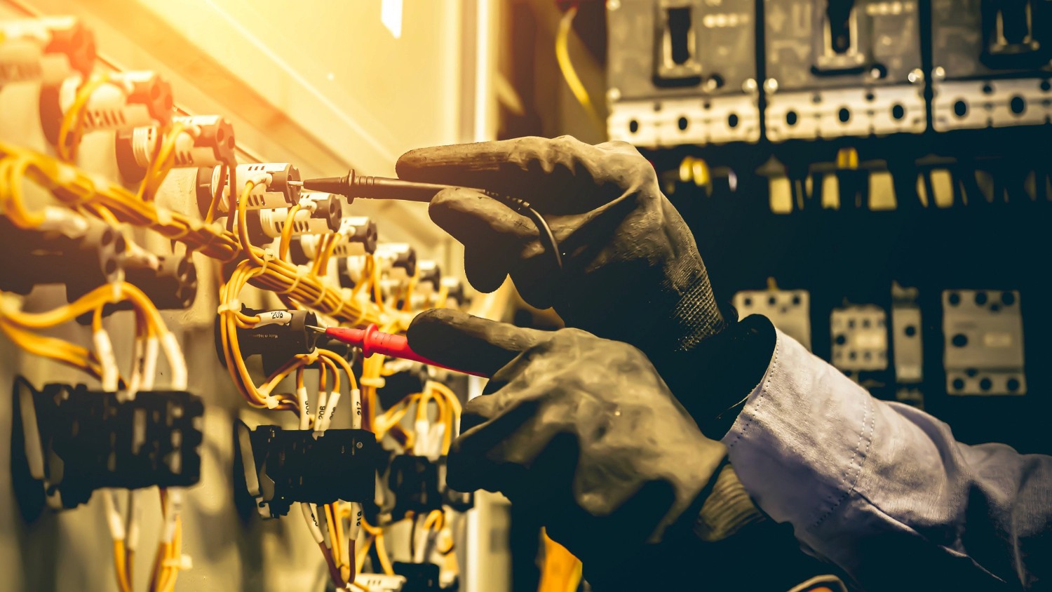 A person's hands working on elecrical board