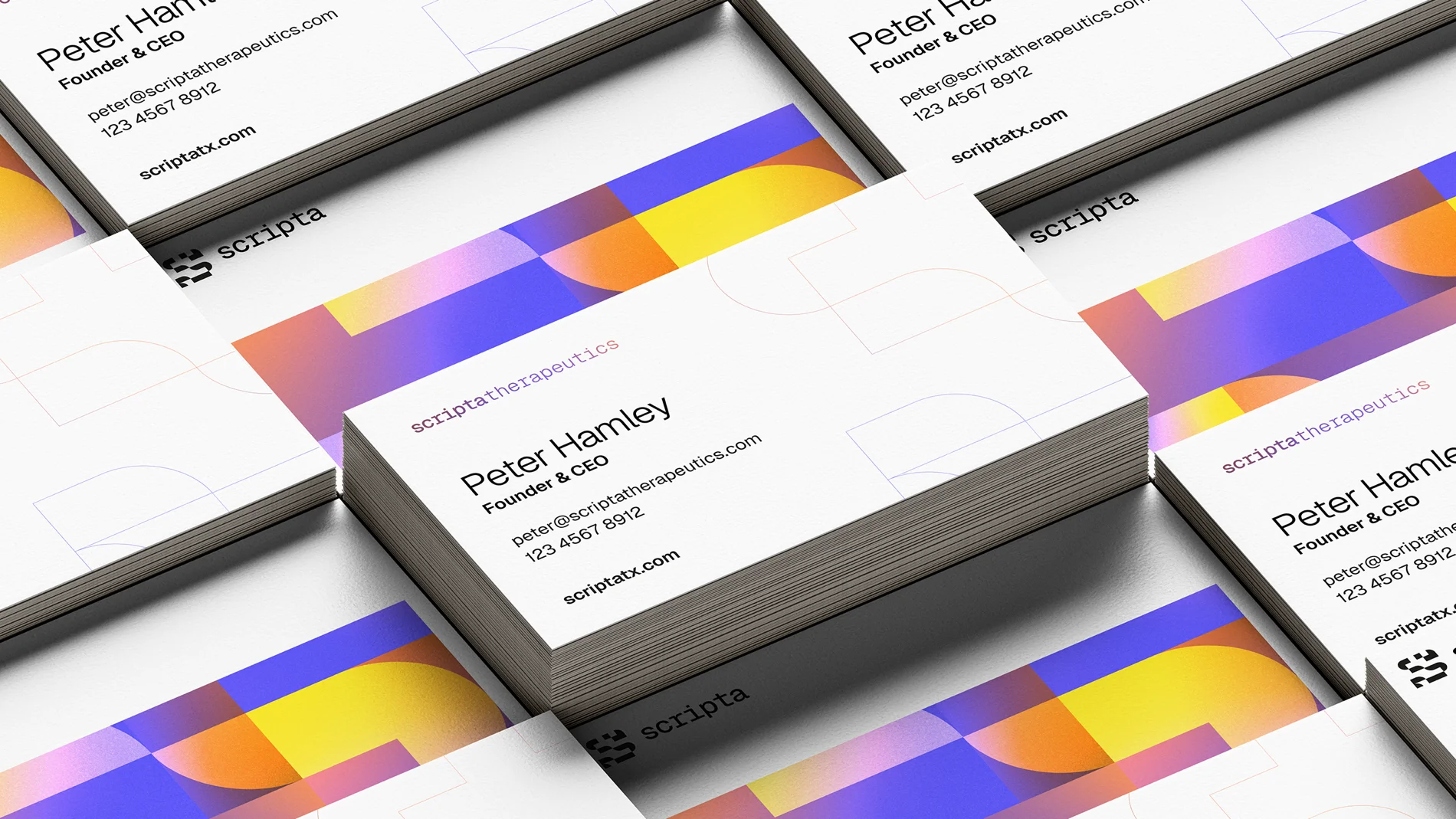 Stacked and scattered Scripta business cards featuring the name Peter Hamley, company contact details, and the colourful brand visuals with abstract geometric patterns.