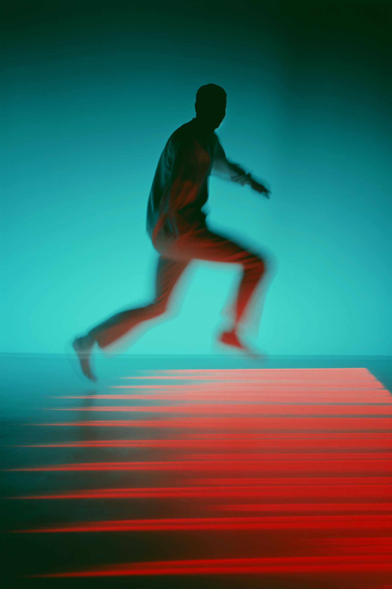 Runner in motion against a teal background, captured mid-stride with motion blur.