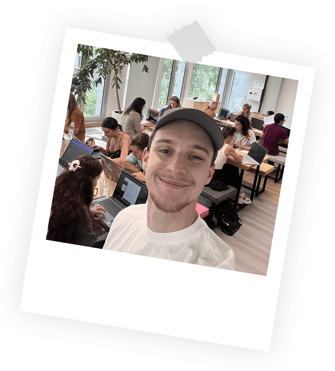 A selfie of Phil with working designers on teh backround during a design workshop