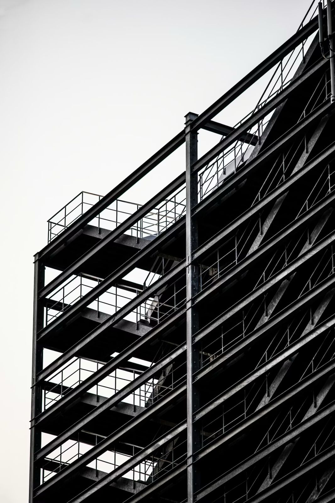 Multi-storey structural steel frame building under construction with exposed beams, columns, and access platforms