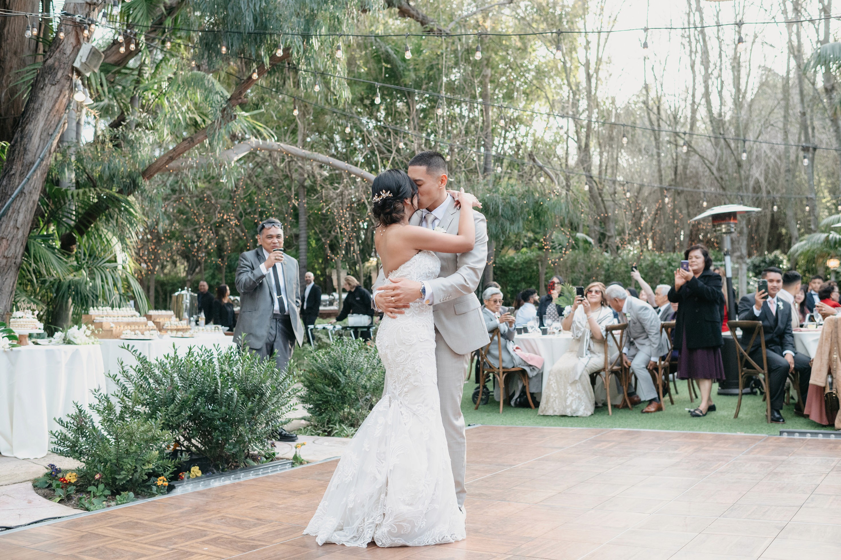 Bride and groom first dance with guests cheering