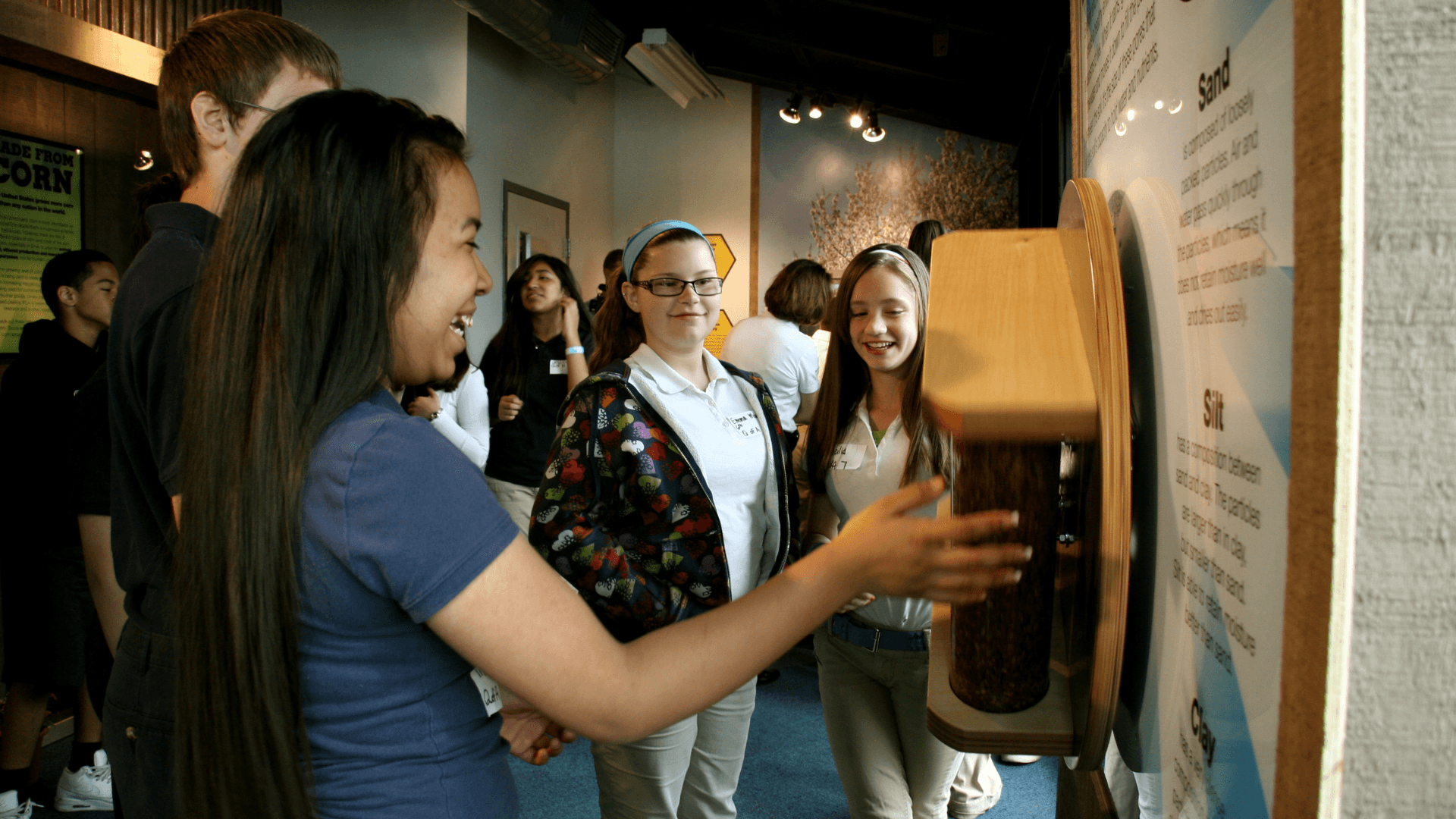 Students watch as water drains through different types of soil.