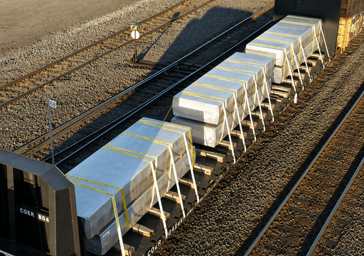 Rail freight with heavy concrete loads secured using dunnage and strapping to ensure load stability and safe transport