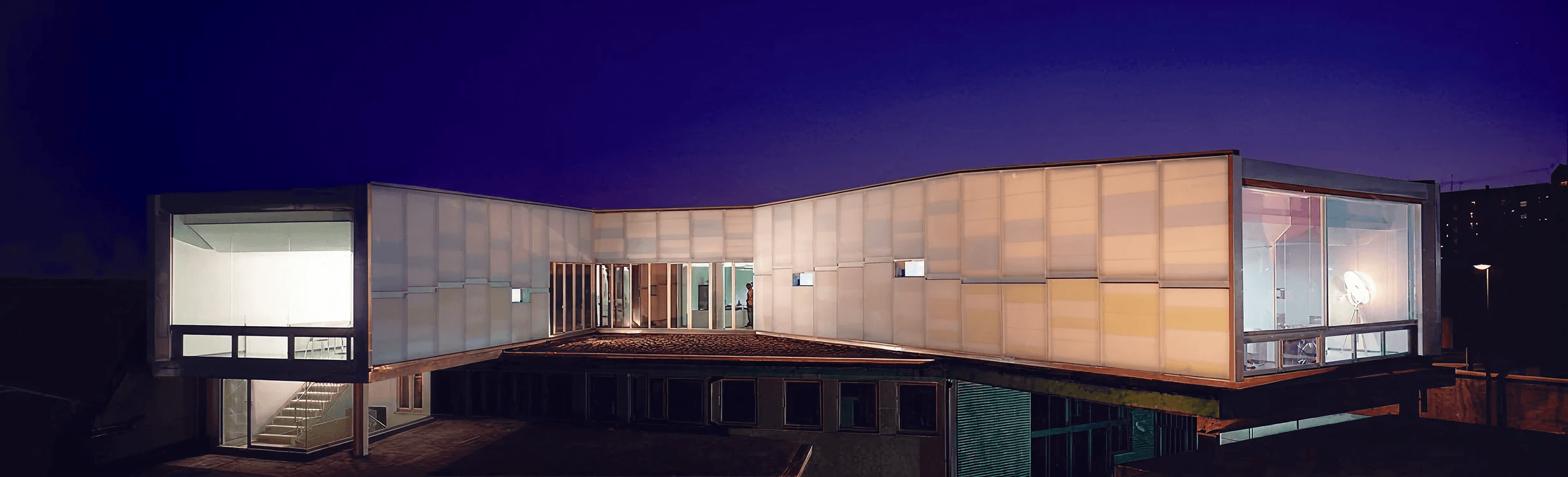 Modern building at night, showcasing innovative architectural design by a multidisciplinary design studio in Turin, Italy specializing in mobility, automotive, industrial, and UX design.