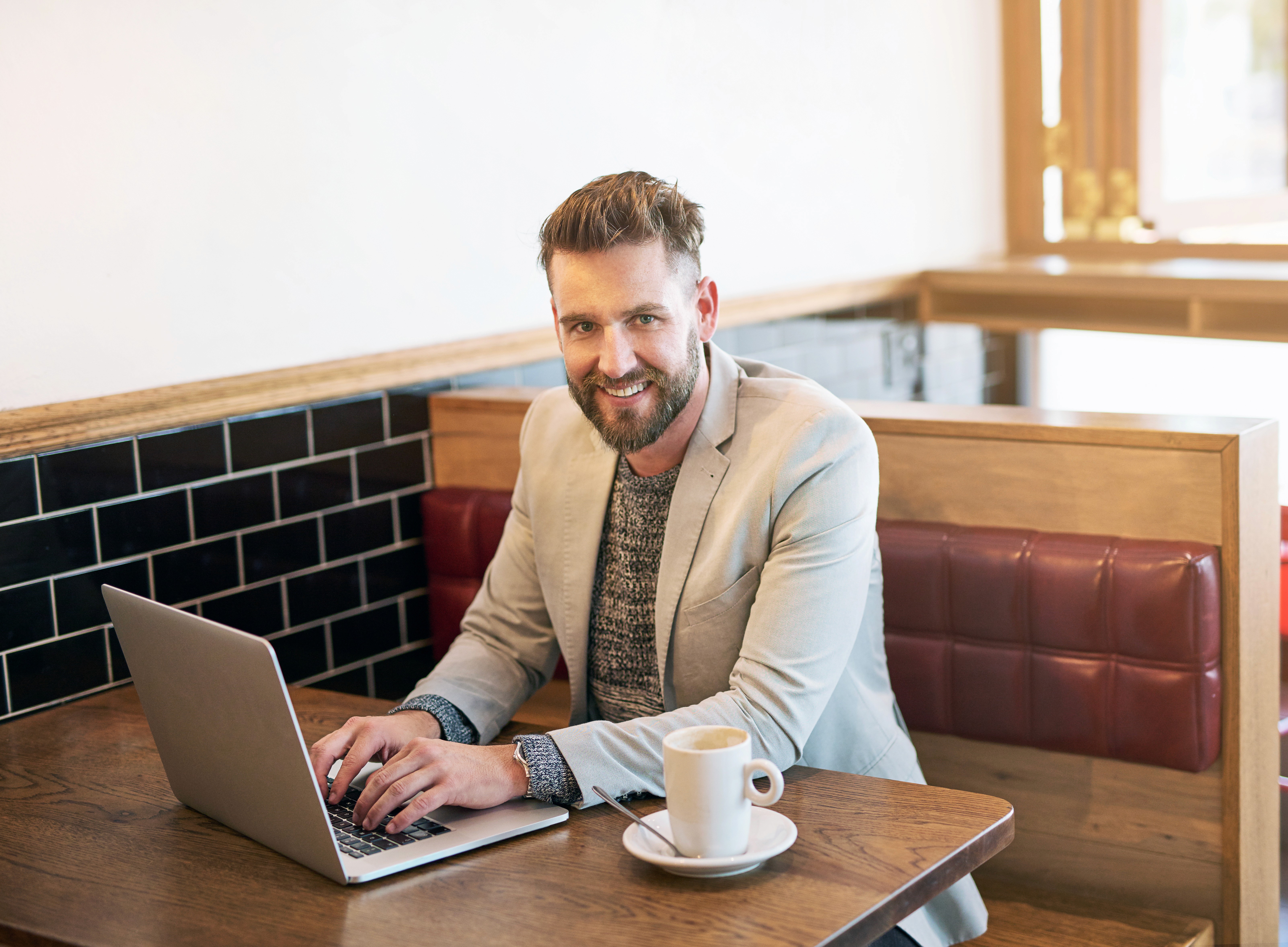 Business owner working on a laptop at a café table