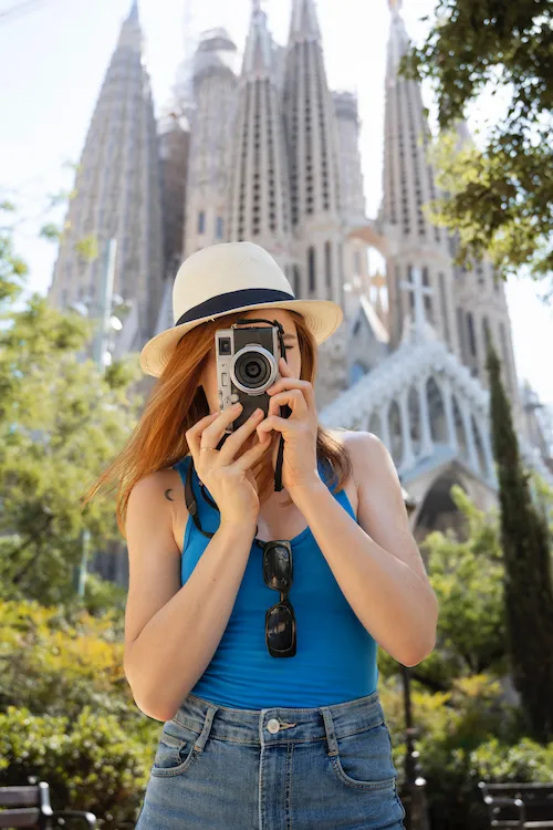 Mulher fotografando ponto turístico europeu durante viagem cultural