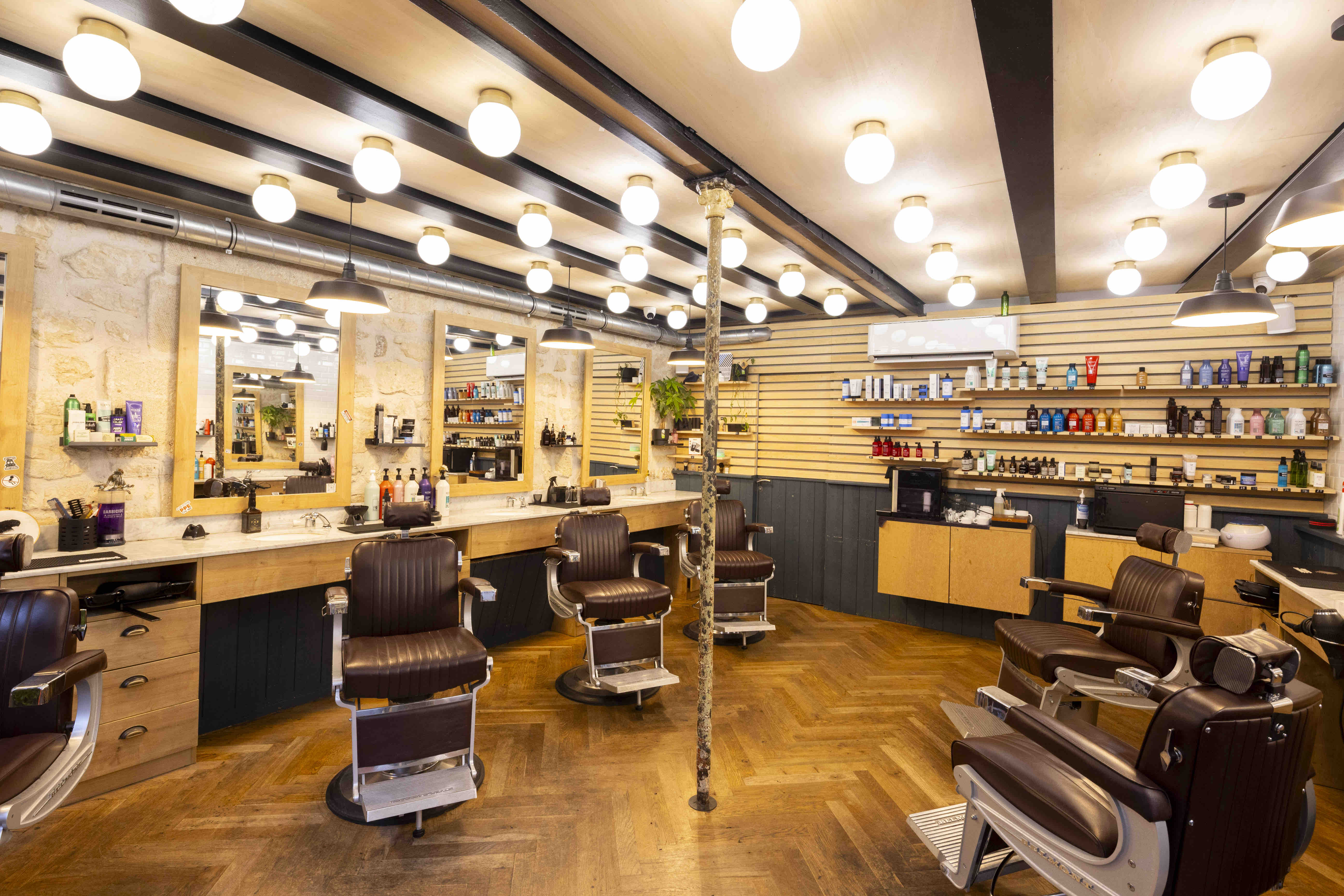 Intérieur spacieux et lumineux d'un barber Bonhomme de ECLA Group à Paris avec rangées de fauteuils