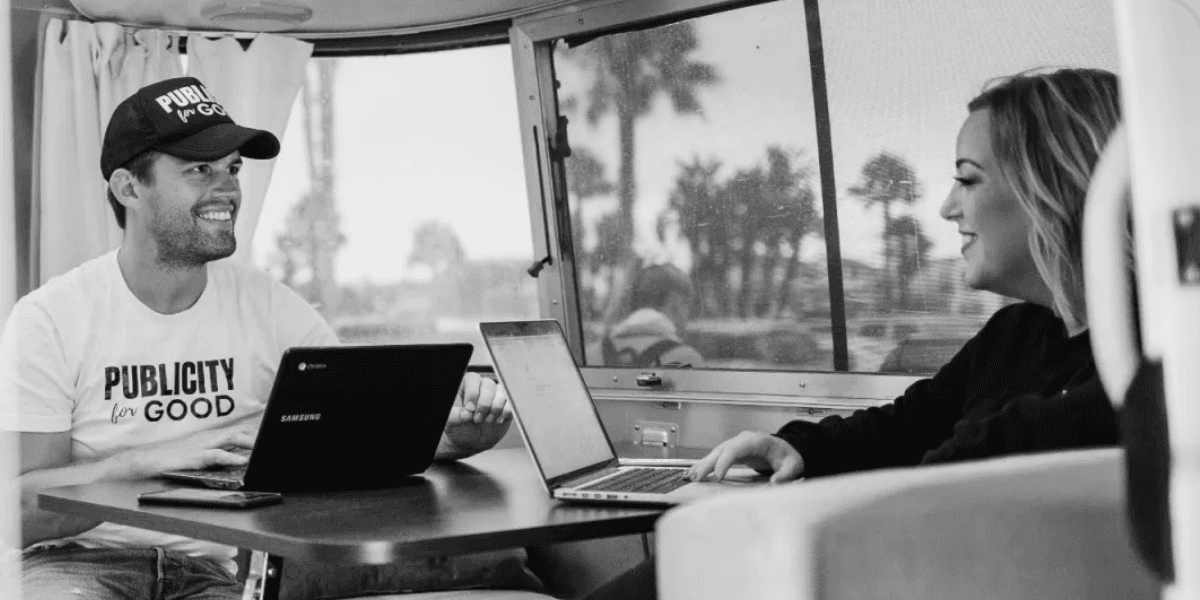 Two people working on laptops inside an Airstream, representing Publicity For Good’s purpose-driven PR initiative.