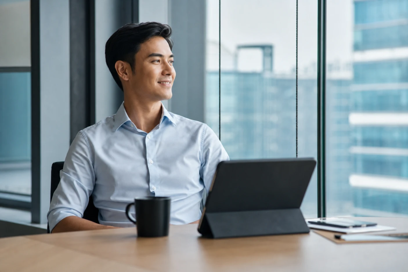 man sitting at desk working on tablet