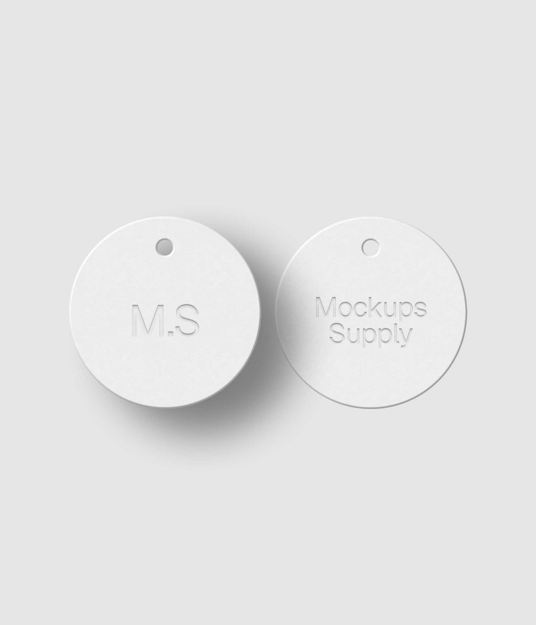 White circular hang tags with realistic debossed branding and soft shadow effect on white surface PSD mockup download