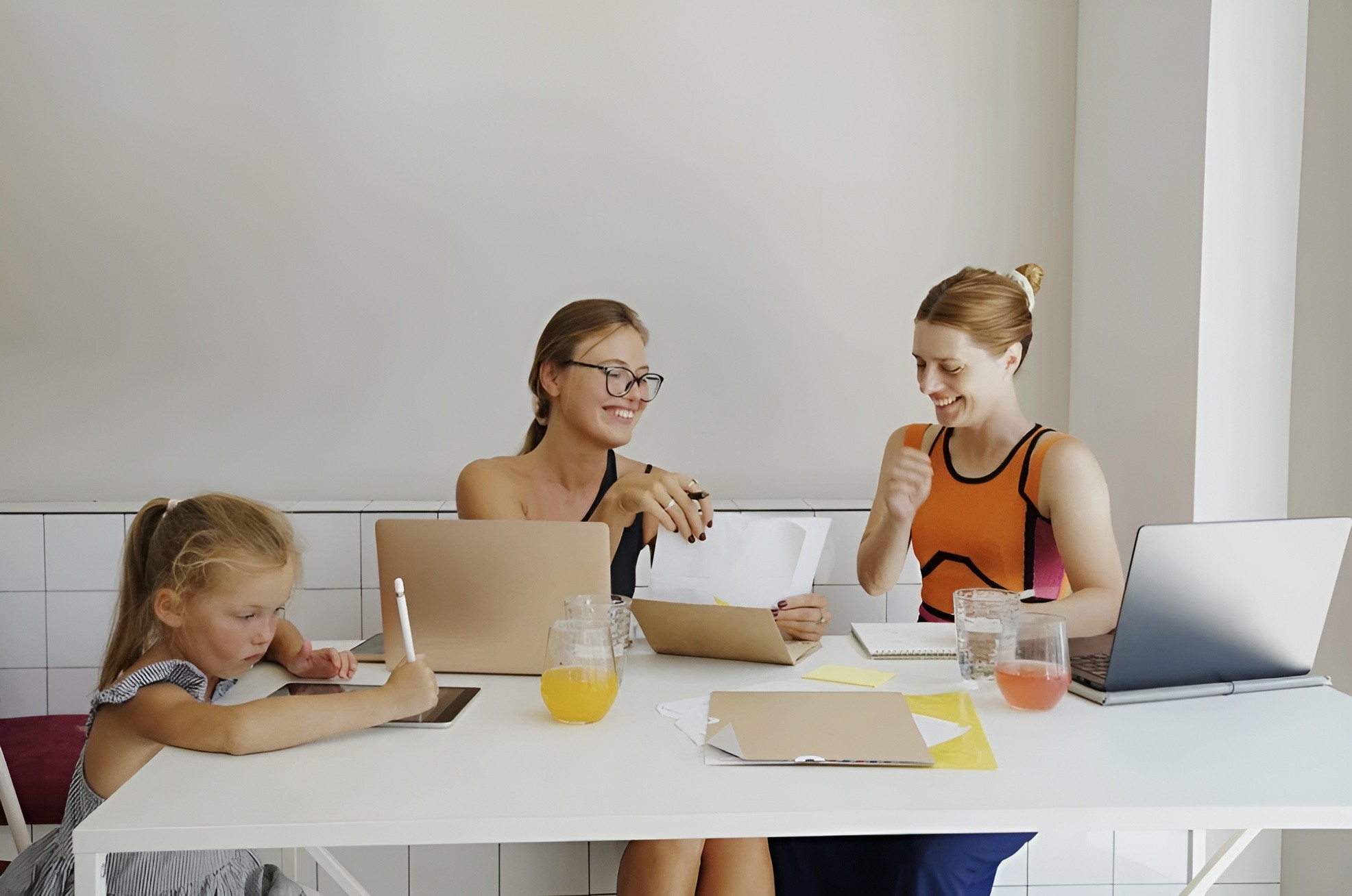two people in a workspace working on their laptops 
