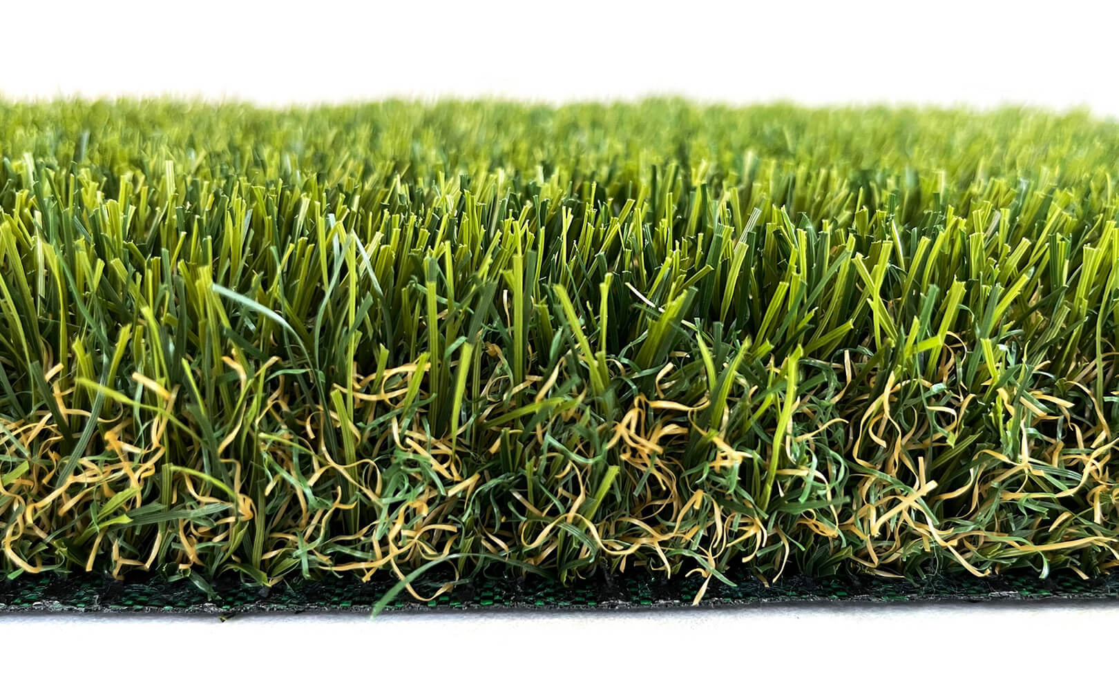 A close-up image of AGL Grass North's stunning Royal 40 artificial turf, with light and dark shades of green mixed with subtle orange fibers at the base.