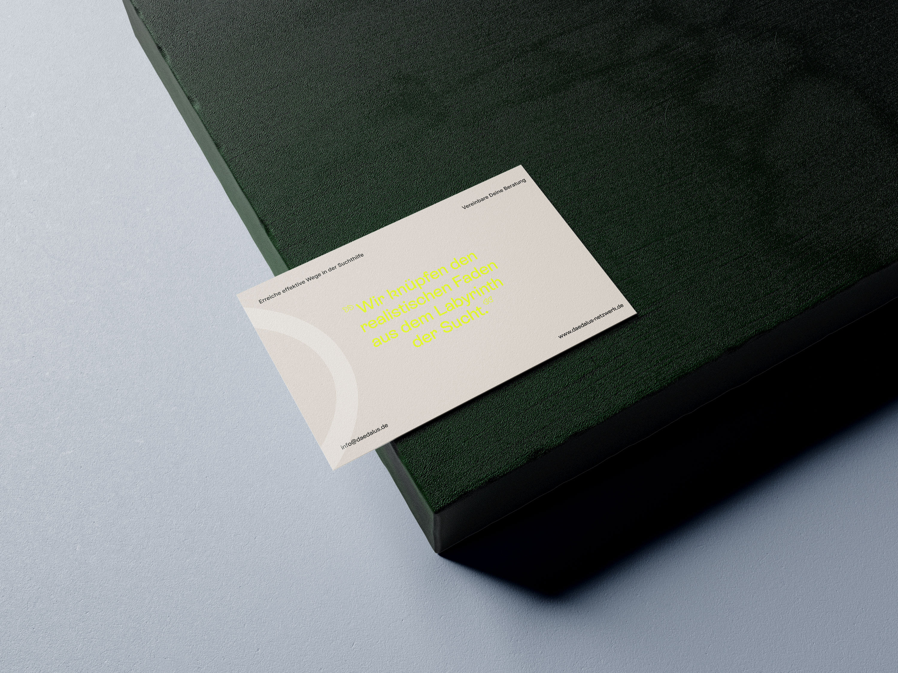 Visitenkarte Rueckseite drapiert auf einer dunkelgruenen Box