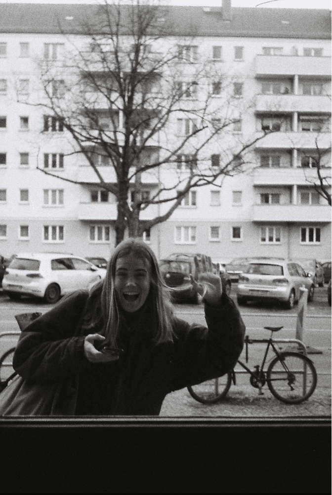 Analog photo of Aga waving at the camera.