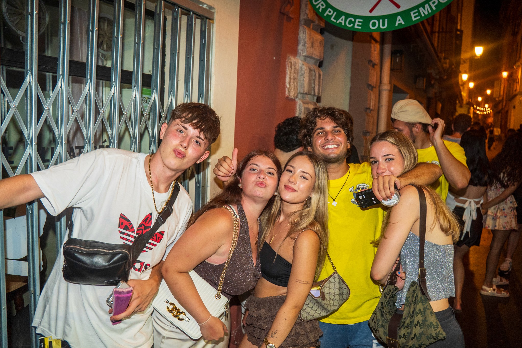 Travelers relaxing on a sunny beach during the day and later enjoying nightlife together in Nice, showing the contrast between beach vibes and evening energy.
