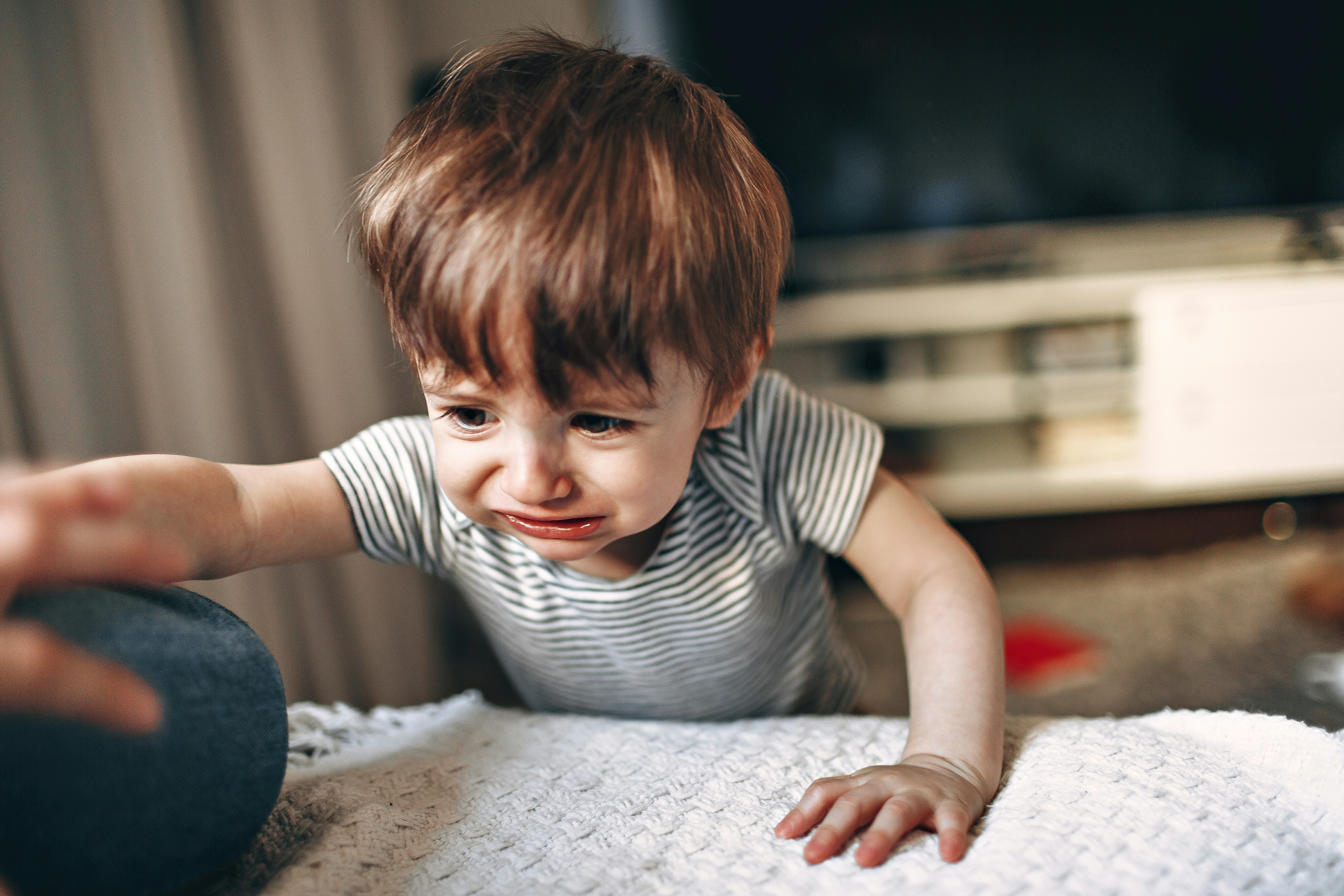 boy in black and white striped crew neck t-shirt sitting on white and gray bed