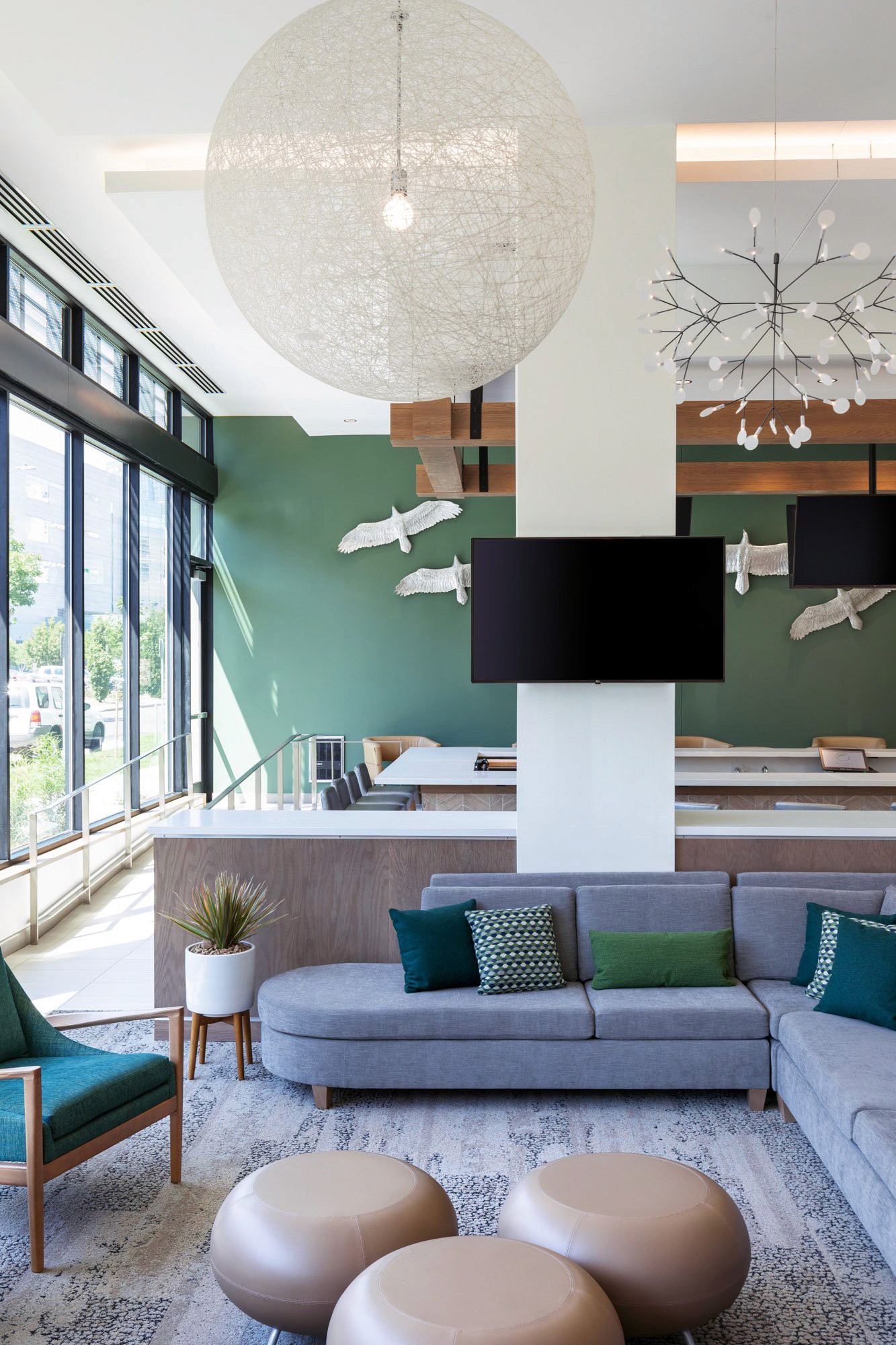 Modern lounge with sofas, bird decor, and screens.