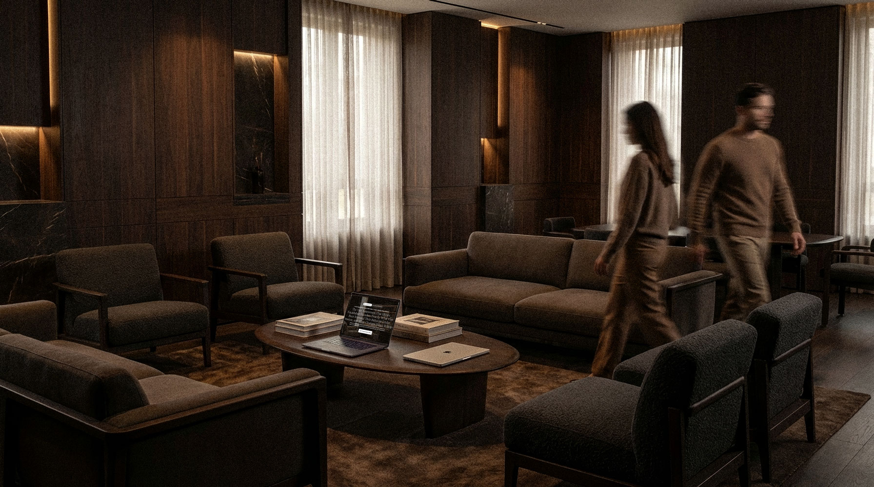 Two people sit at a dark wooden table, smiling warmly at the camera. They have laptops open, creating a friendly and collaborative atmosphere.