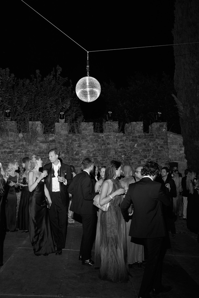 Black-and-white image of crowd on dancefloor, mingling and talking to each other