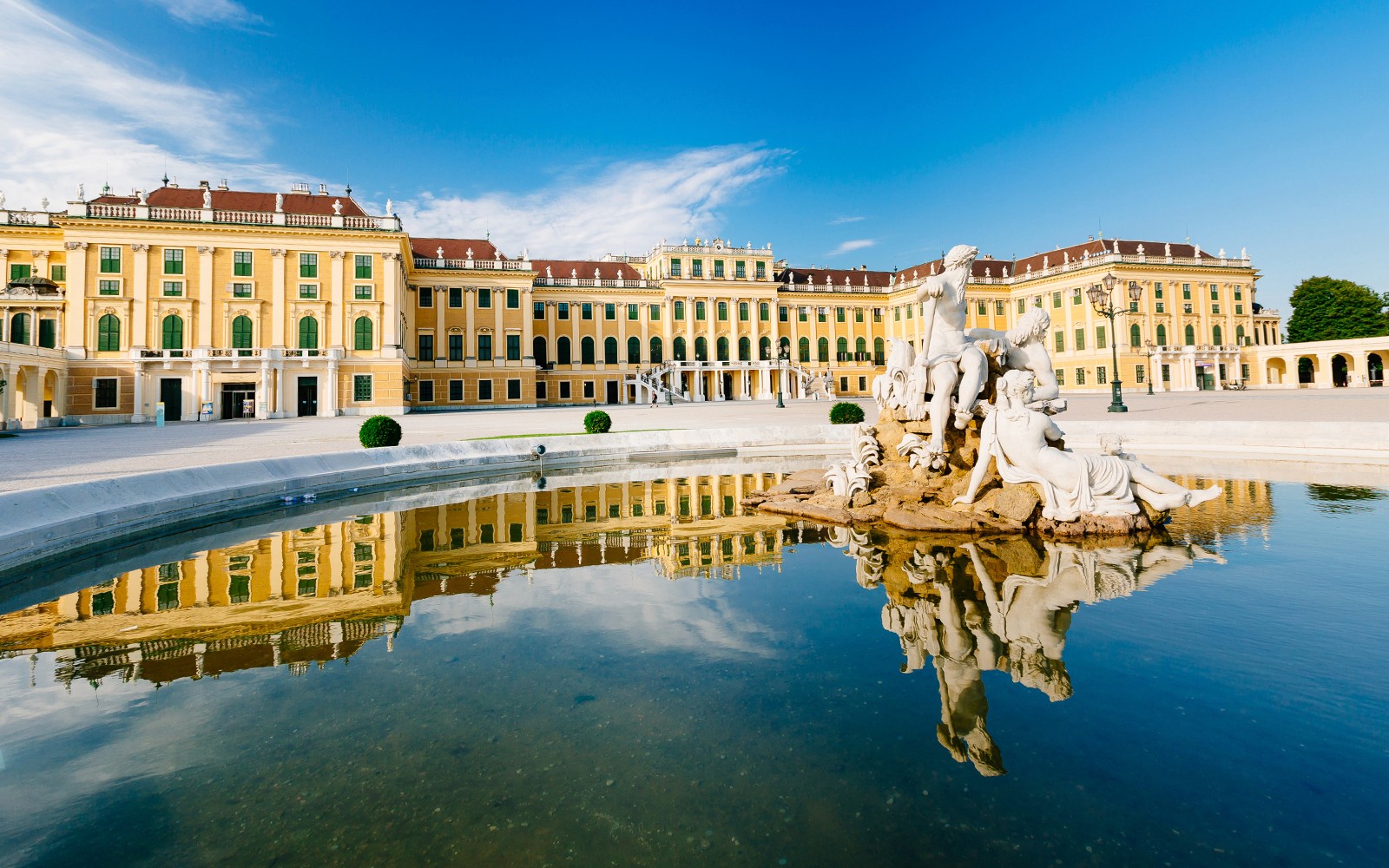Palatul Schönbrunn cu Fântâna lui Neptun în Viena, Austria, reflectându-se în apă.