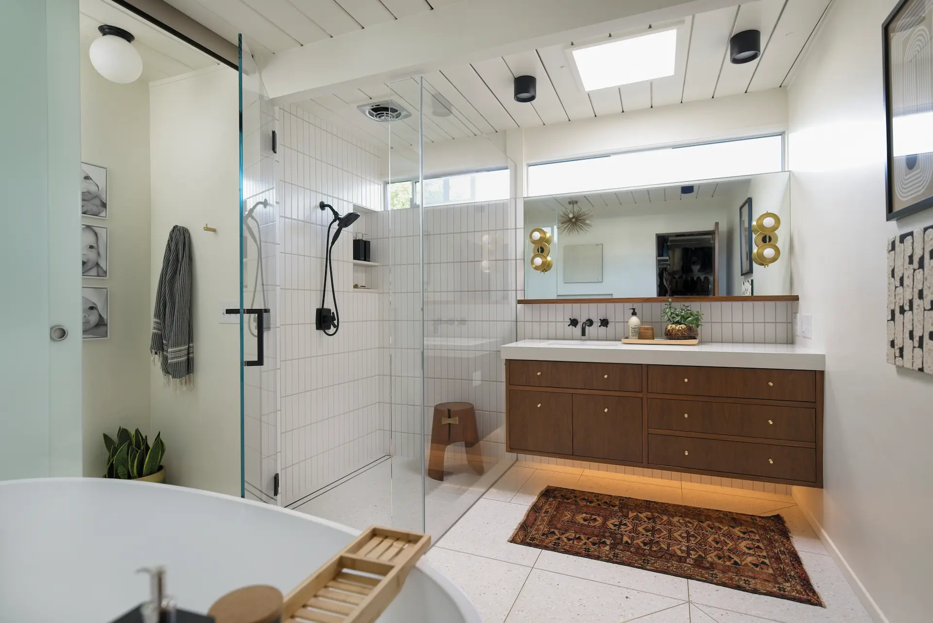 Expansive view of the primary bathroom, highlighting the shower area, vanity, and overall design in the Fairhaven Eichler Tract remodel. Photo by Todd Huge.