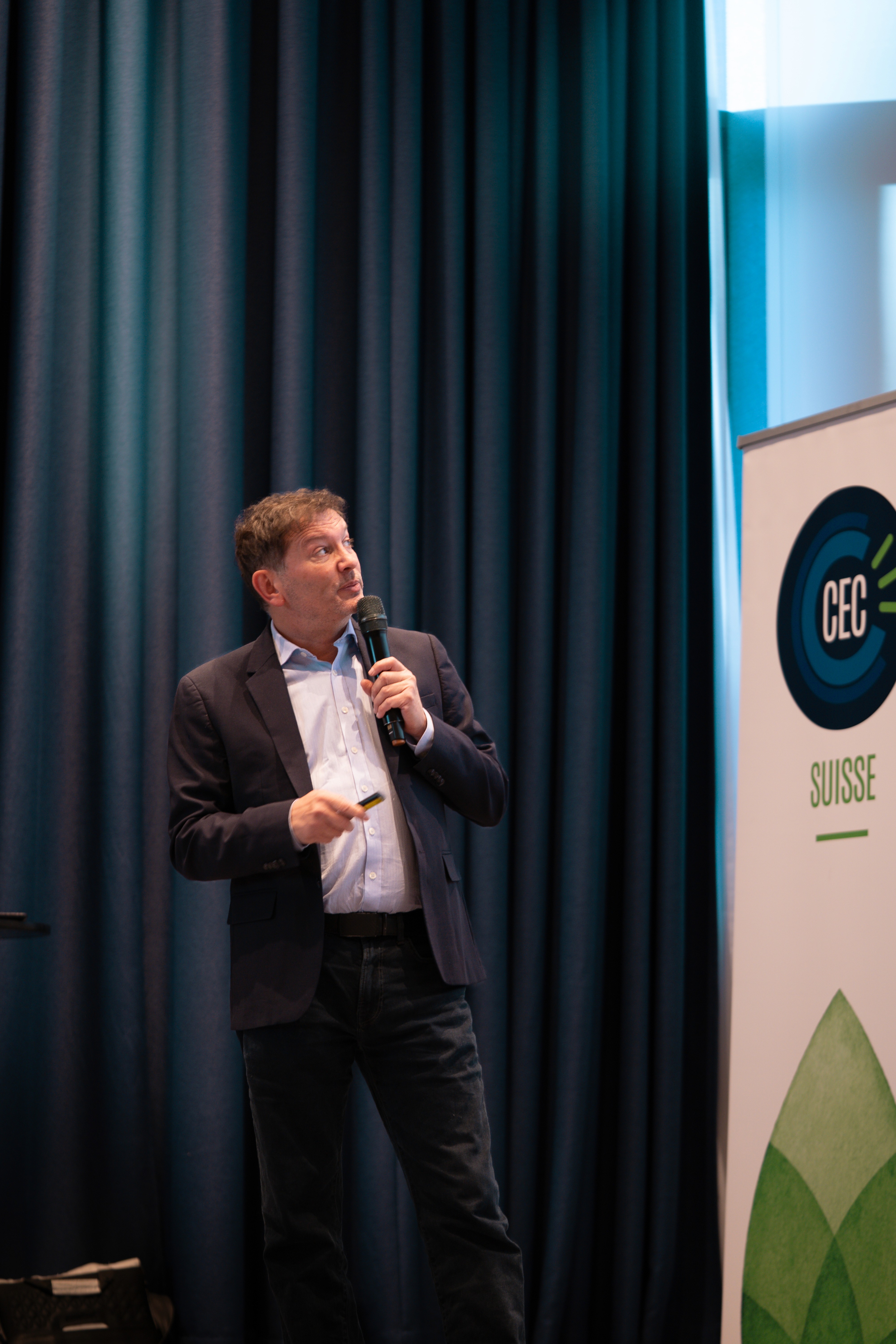 Close-up of a dark green leaf showing its textured surface and central vein against a muted background.