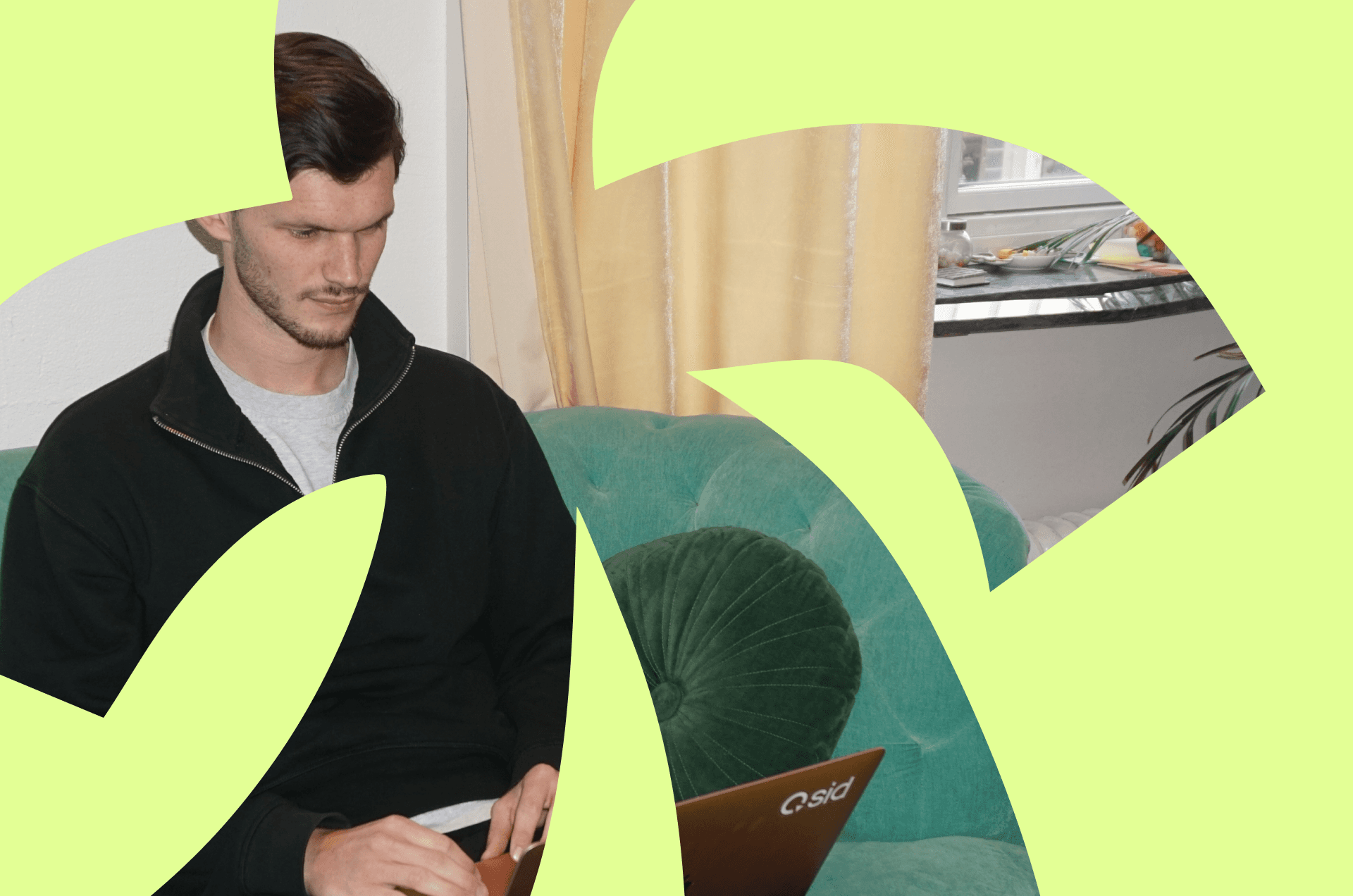 Person seated on a teal sofa with a laptop, representing the difference between personal brand and business brand in B2B growth for 2026