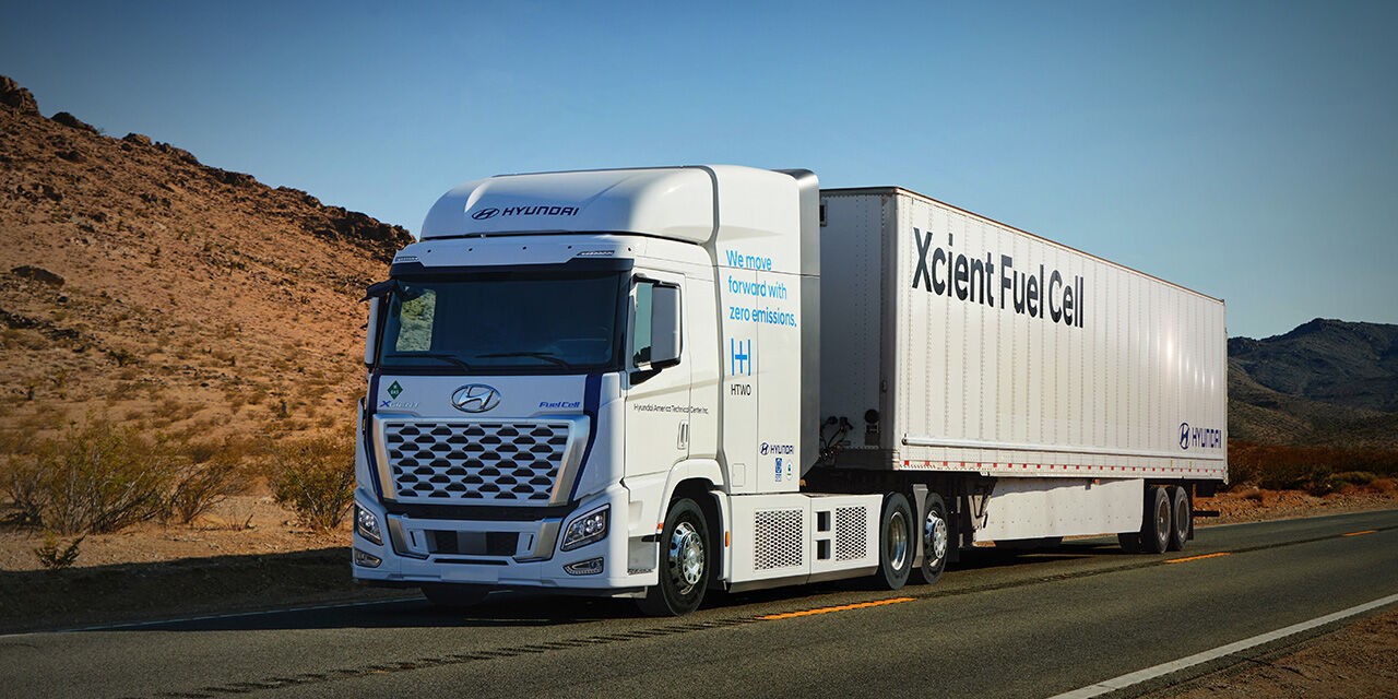 Hyundai Xcient Hydrogen Truck driving on a highway, showcasing clean energy logistics innovation.