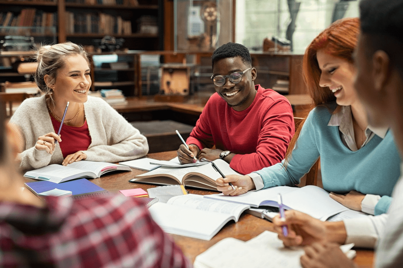 Sudents studying together in library - best colleges international students