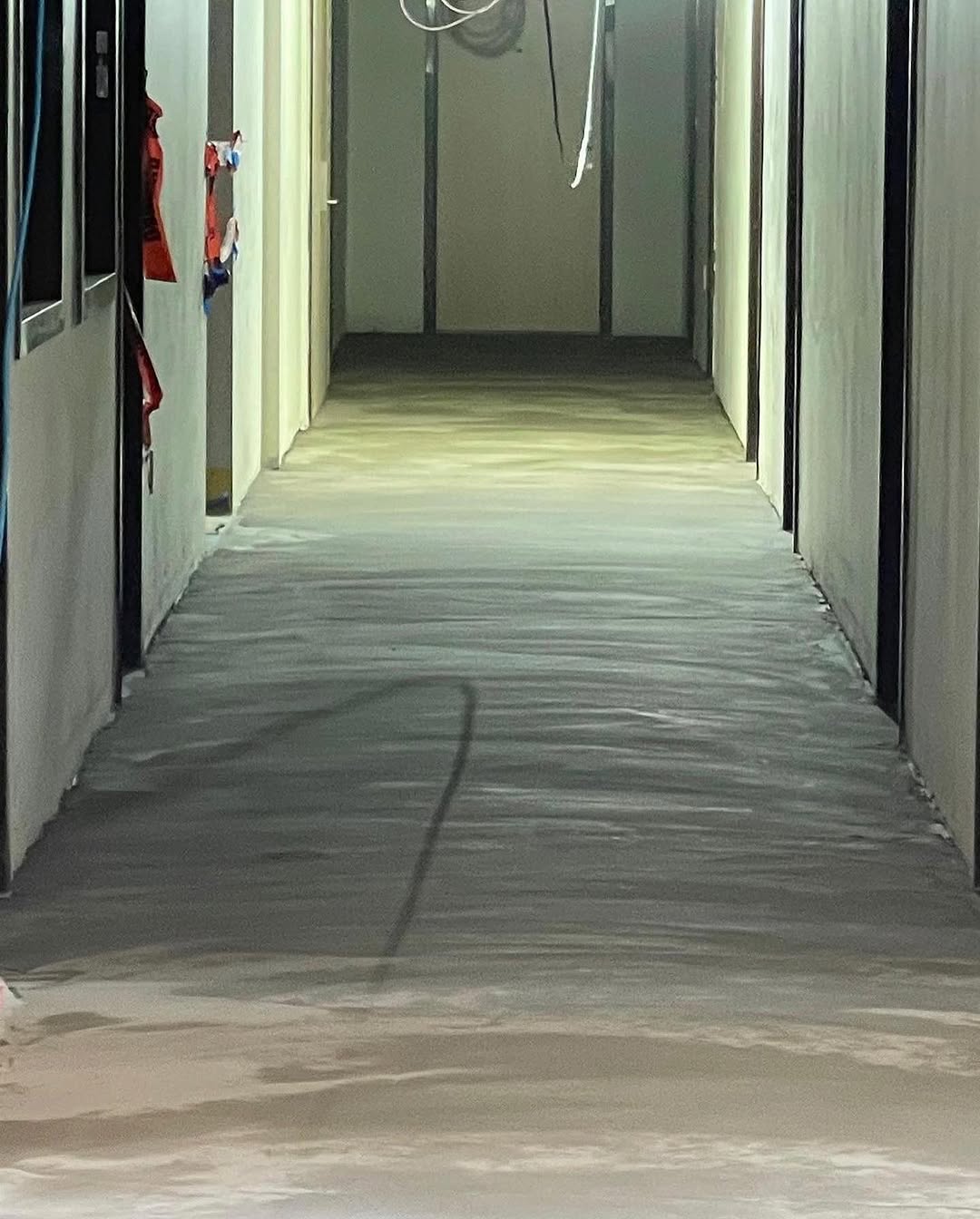 Freshly poured underlayment smoothed the length of a corridor