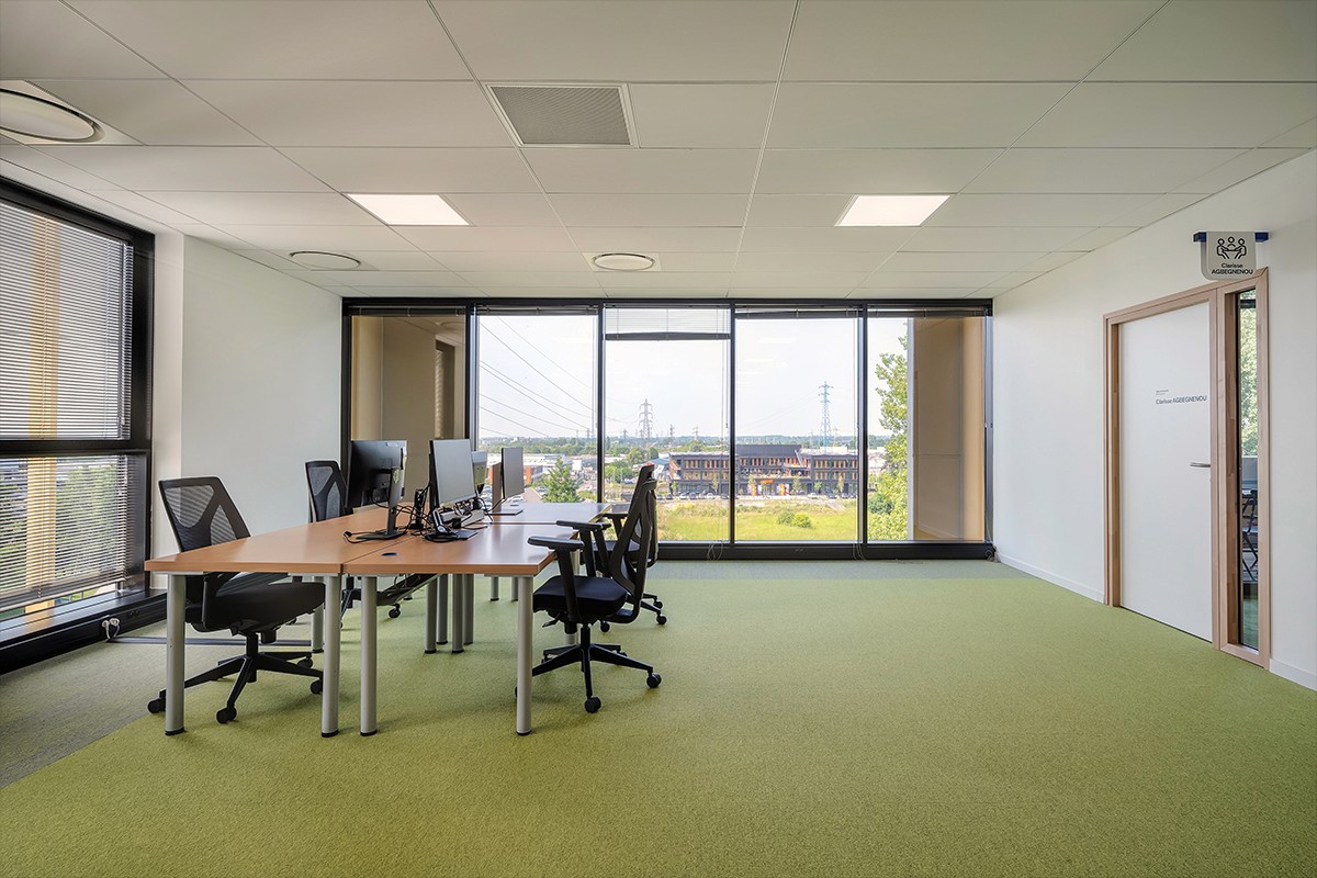 openspace avec grandes baies vitrées table haute de visios dans un bureaux avec vitres sur l'extérieur  — photographie architecture intérieure Lille Nord | Anteale Yann Manac’h 2025