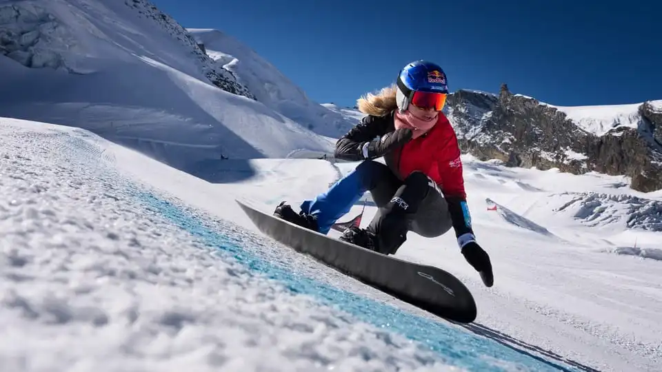Professional snowboarder racing downhill on snow