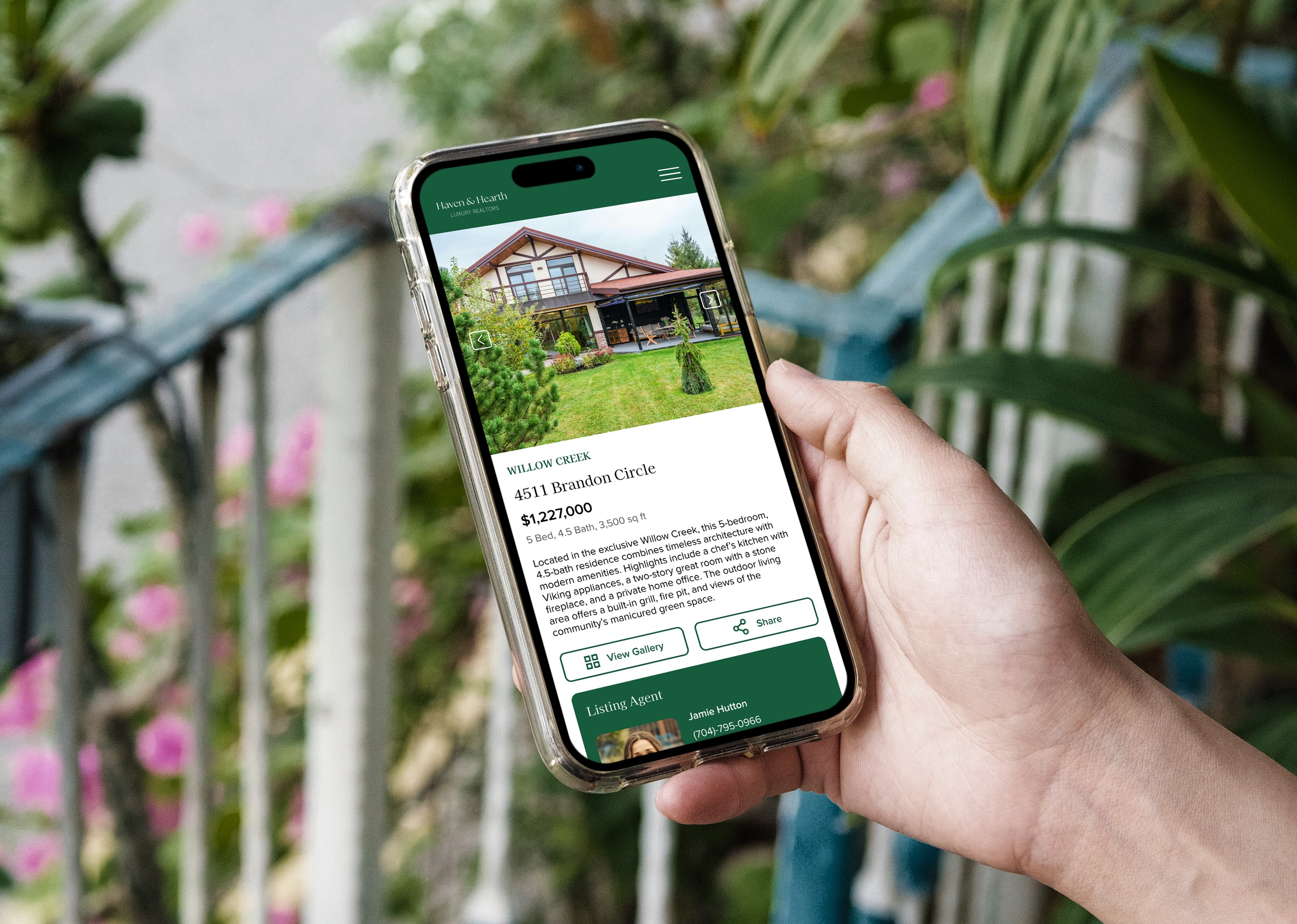 A hand holding a phone with a real estate website