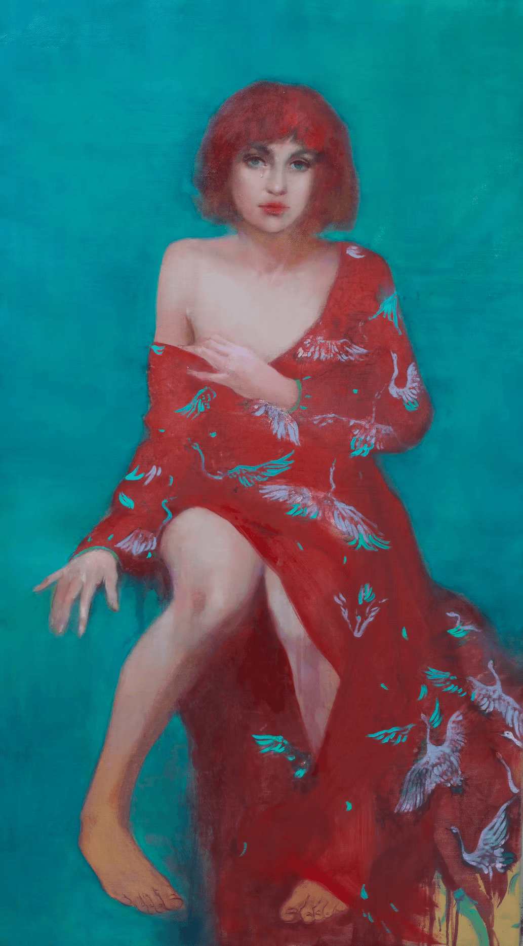 A woman with red hair sits against a teal background, wearing a red dress adorned with white birds, allowing one shoulder to be exposed for an elegant and serene pose.
