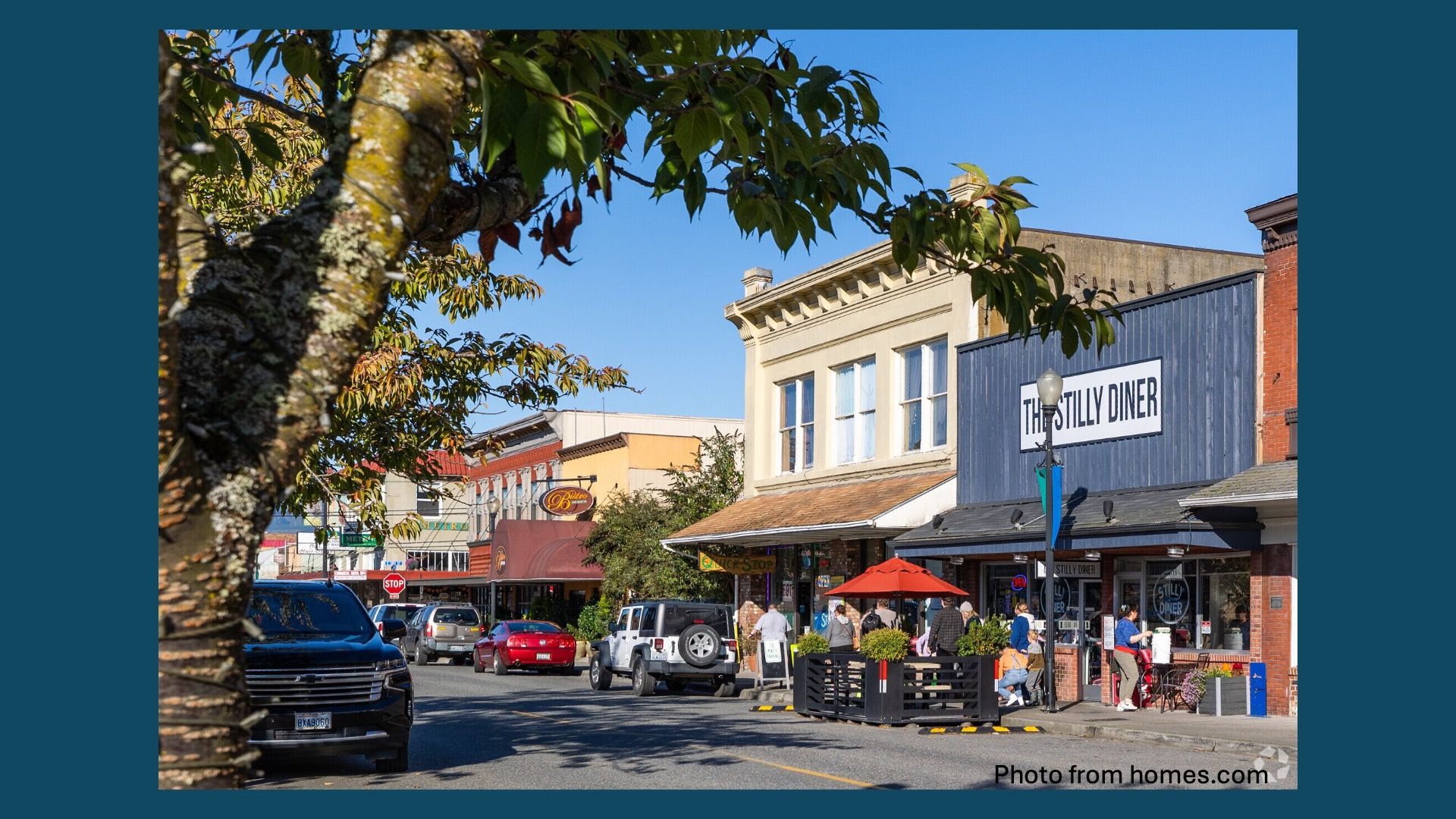 Rooted Northwest community members standing together in a field at dusk with a rainbow over farmland