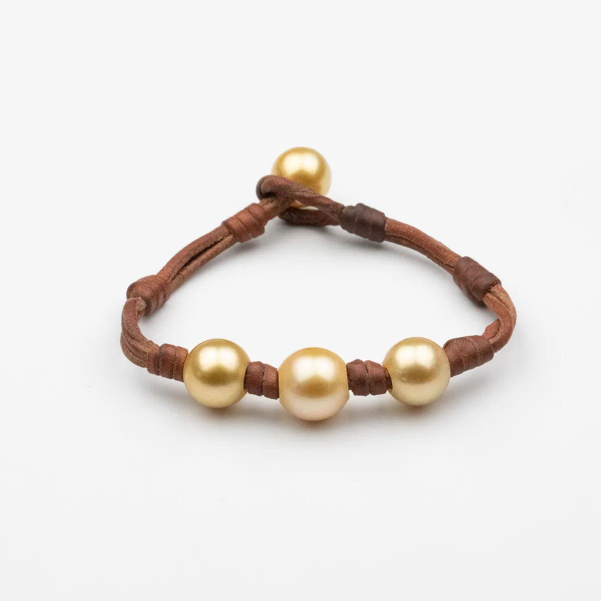 South Sea Pearl leather bracelet with four golden pearls hand-knotted on brown leather cord with pearl toggle closure — Manos de Oro Saint Barth