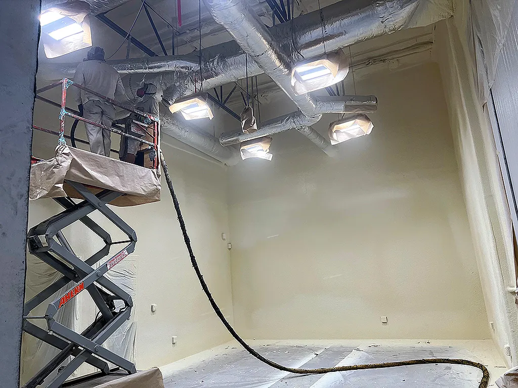 Spray foam insulation system being installed