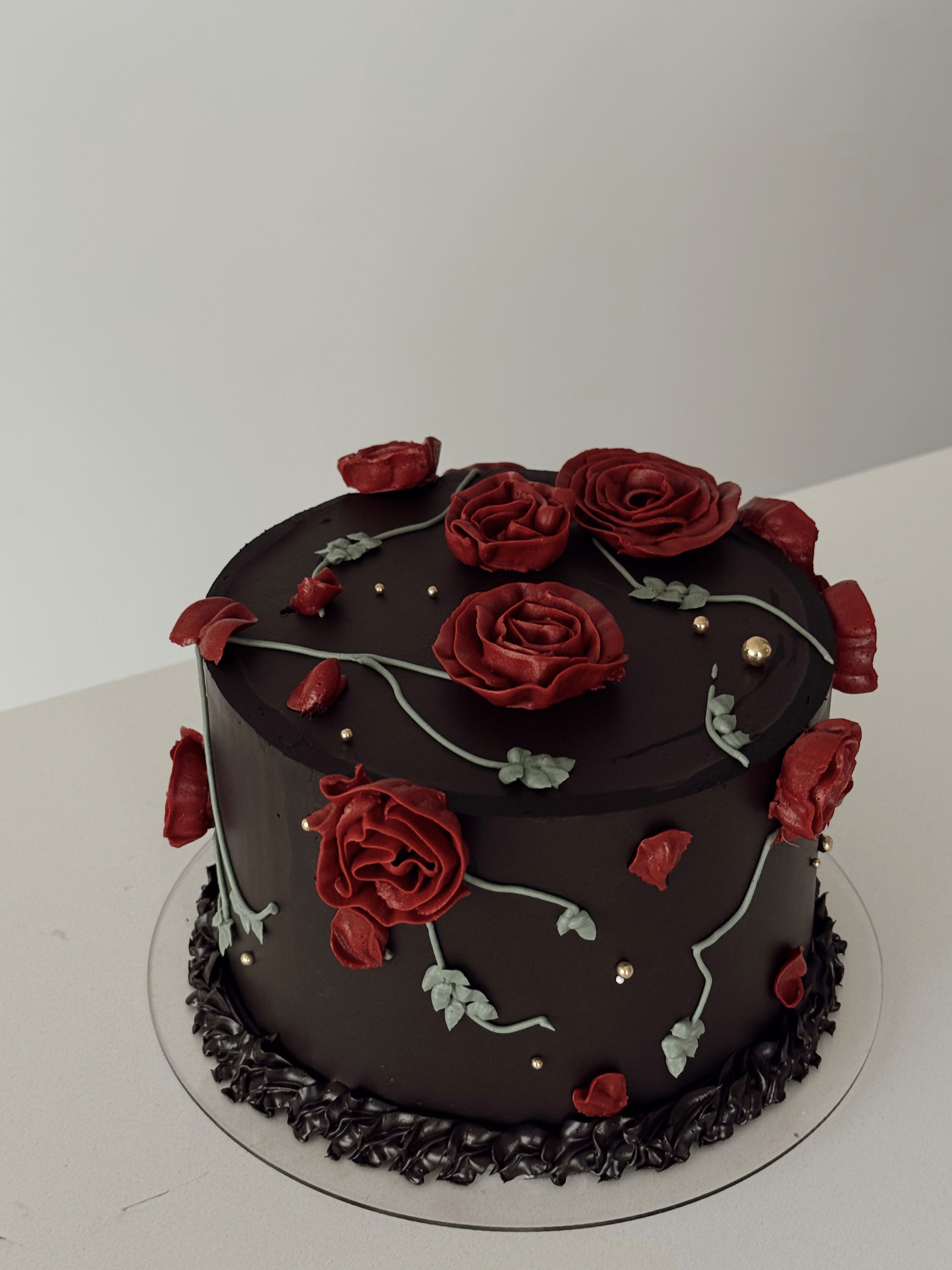 Cream-colored buttercream cake decorated with pastel floral piping