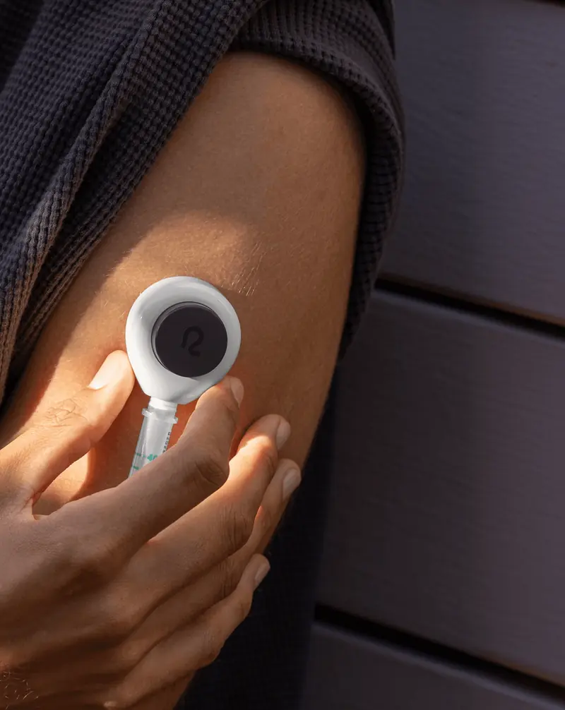 Close-up of a person placing a Rythm device on their upper arm.