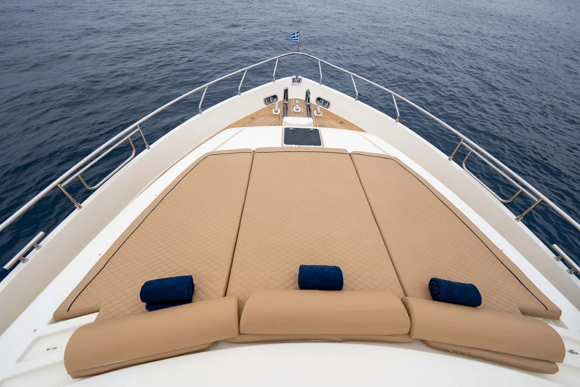 White Rock 36 speedboat with captain at helm cruising calm blue waters near Paros coastline with hills in background.
