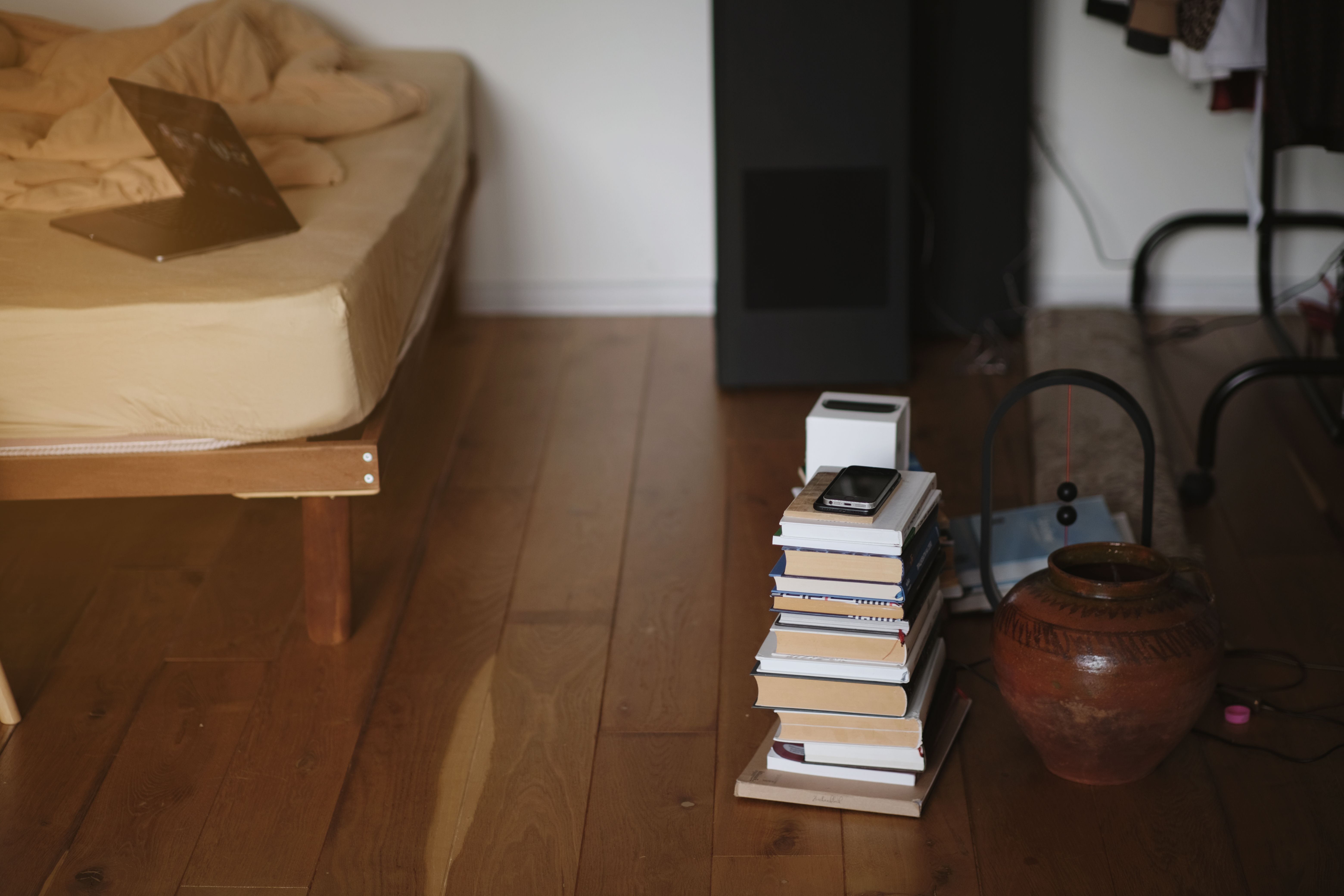 a-warm-and-inviting-bedroom-with-stacks-of-books,-pottery,-and-a-wooden-bed-fram - oleg-melevych (pexels)