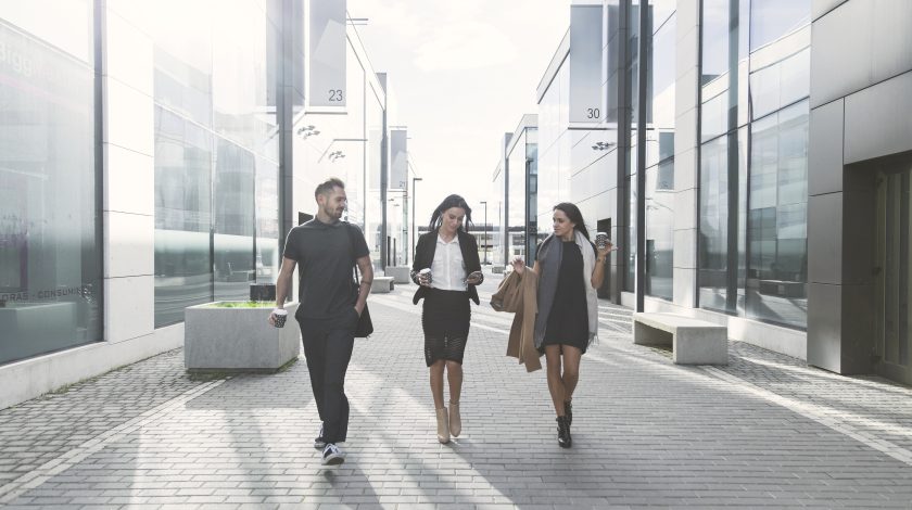 A sleek workspace featuring a laptop, tablet, and smartphone placed on a wooden desk, highlighting modern technology and connectivity.