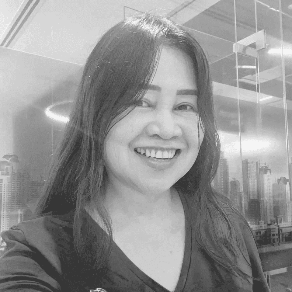 A woman examining a large architectural drawing on a table in a modern studio. Shelves and neatly arranged supplies surround her.