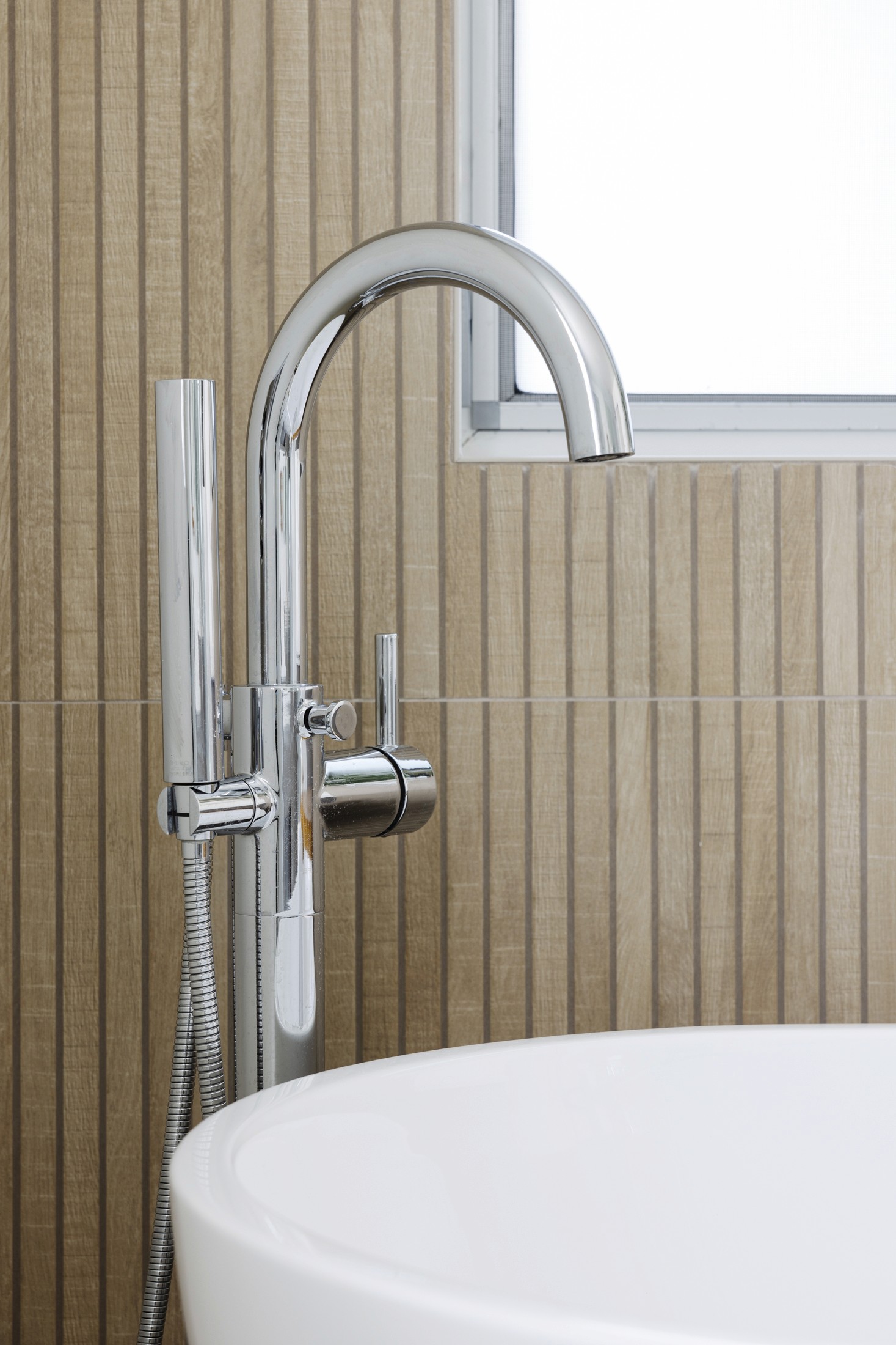 Close up view of stand alone bathtub with chrome faucet