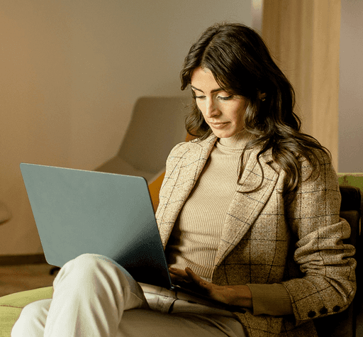 Mulher usando notebook em ambiente corporativo, representando consultoria tributária.