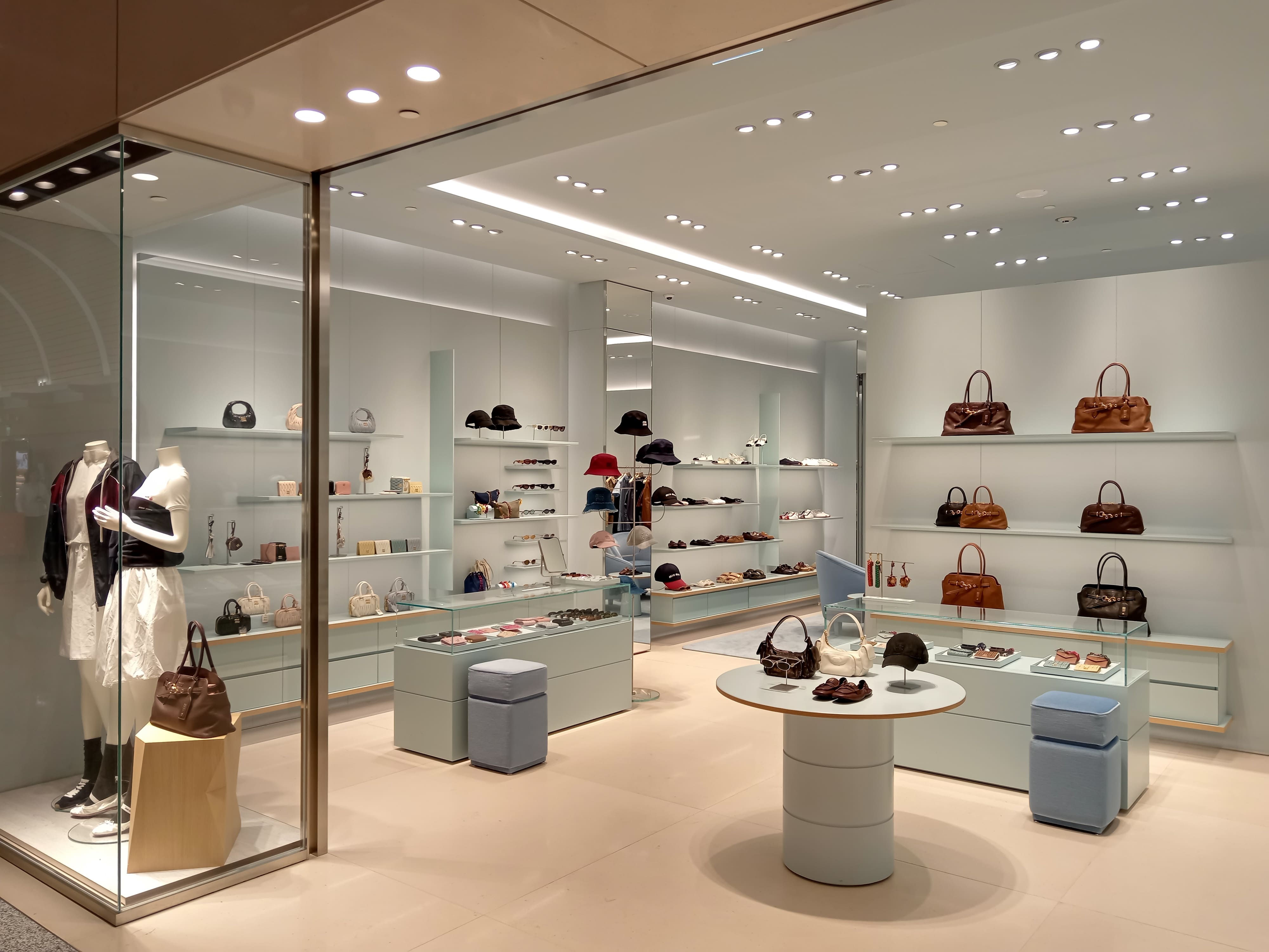 MW Interior Einzelhandelseinrichtung – elegante Handtaschenboutique mit modernen Präsentationsflächen und hellem Interieur